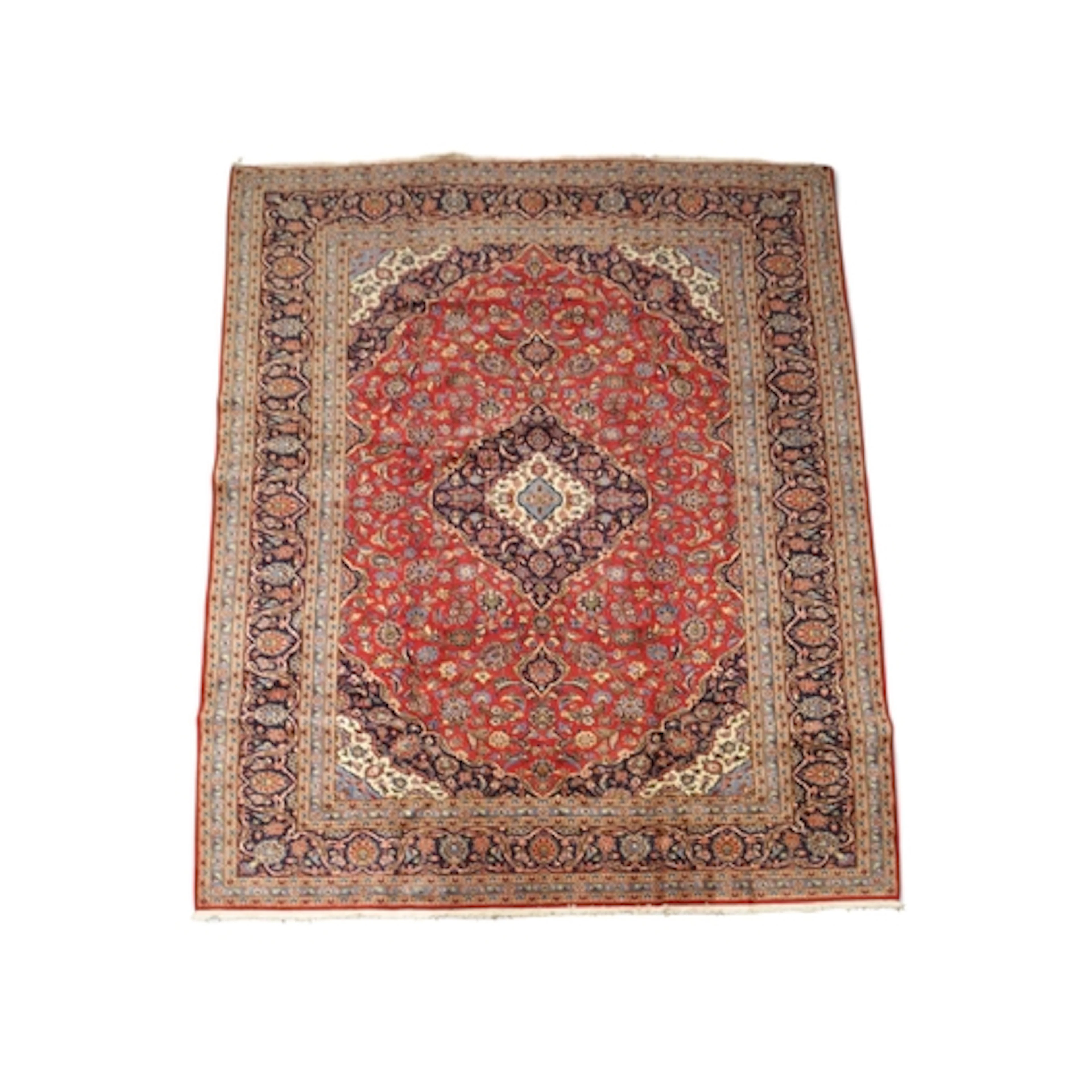 A RED GROUND DEEP PILE KASHAN RUG with dark blue and c...