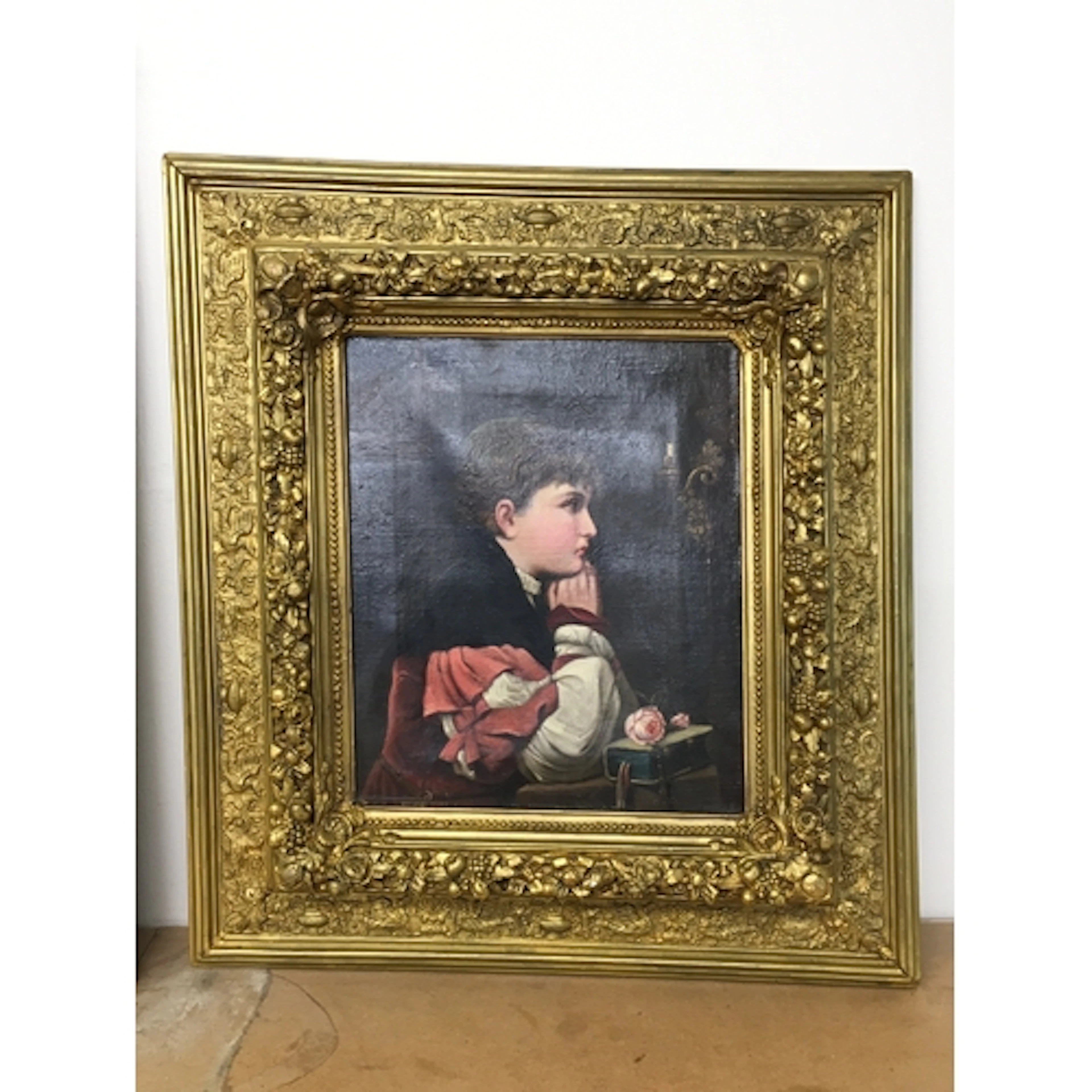 A 19th-century oil painting on canvas of a young boy resting...