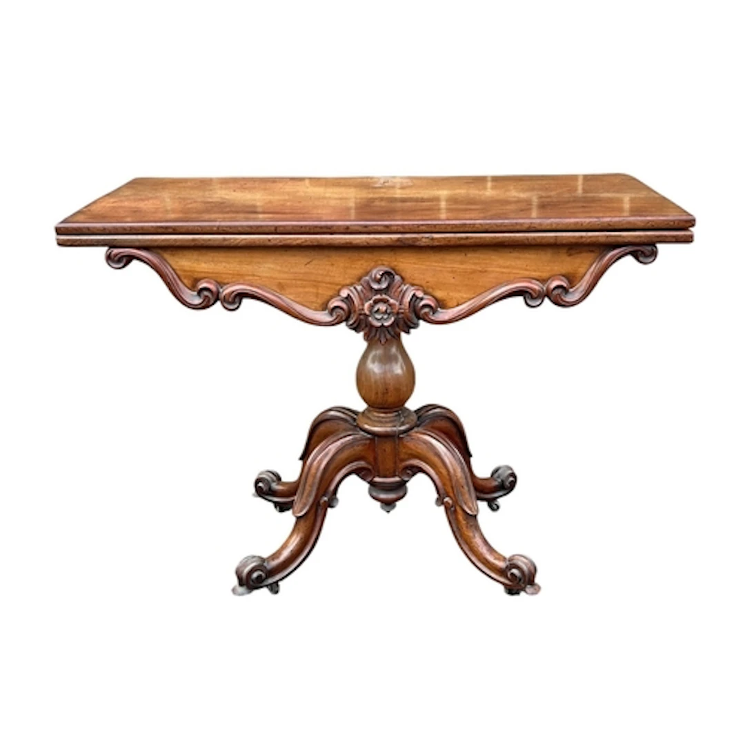 AN EARLY VICTORIAN MAHOGANY FOLDING TEA-TABLE With carved de...