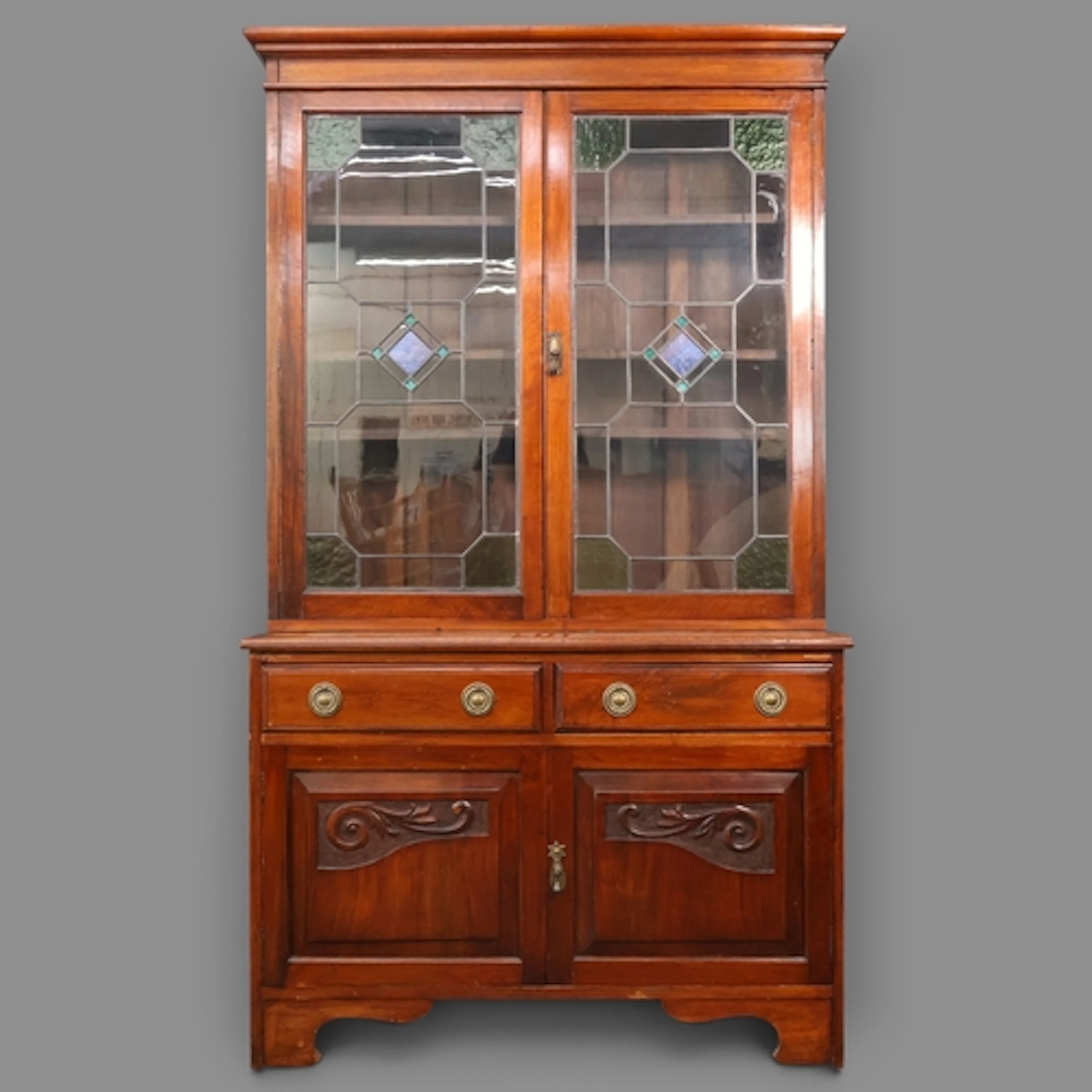 An Art Nouveau two section Library bookcase with two leadlig...