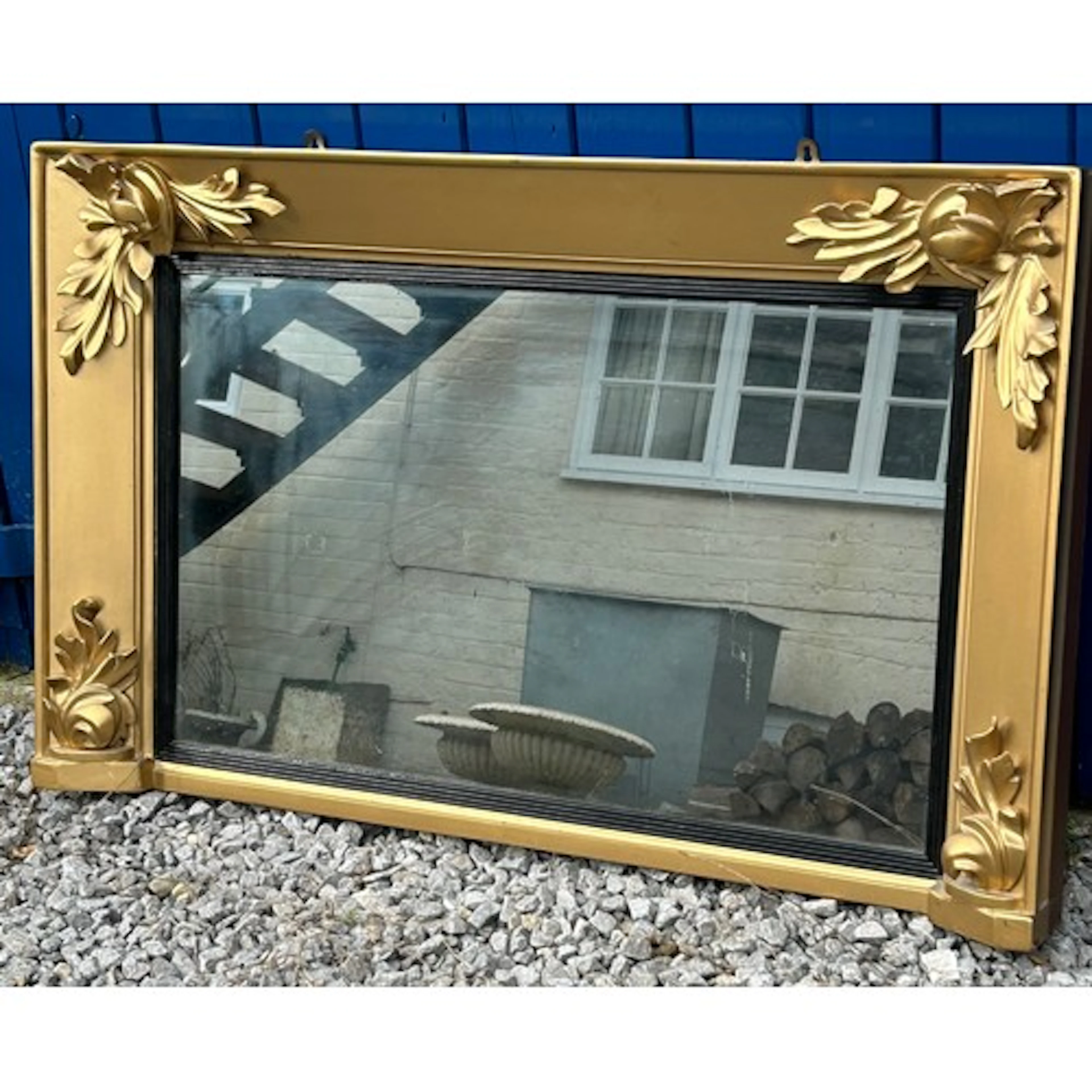 A gold painted mantel mirror with decorative corners measuri...