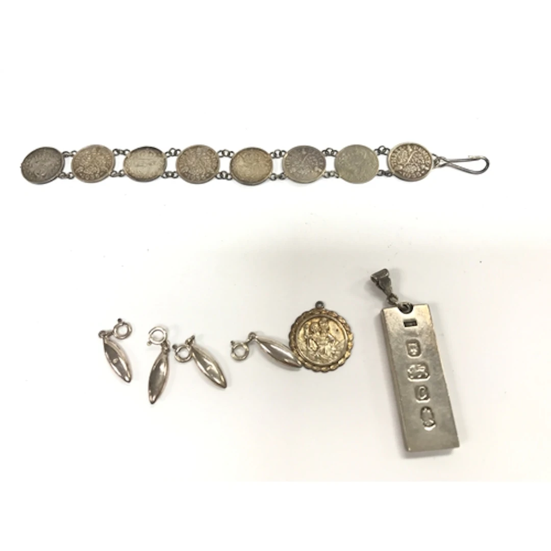 A silver ingot pendant, silver pendants and a silver coin br...