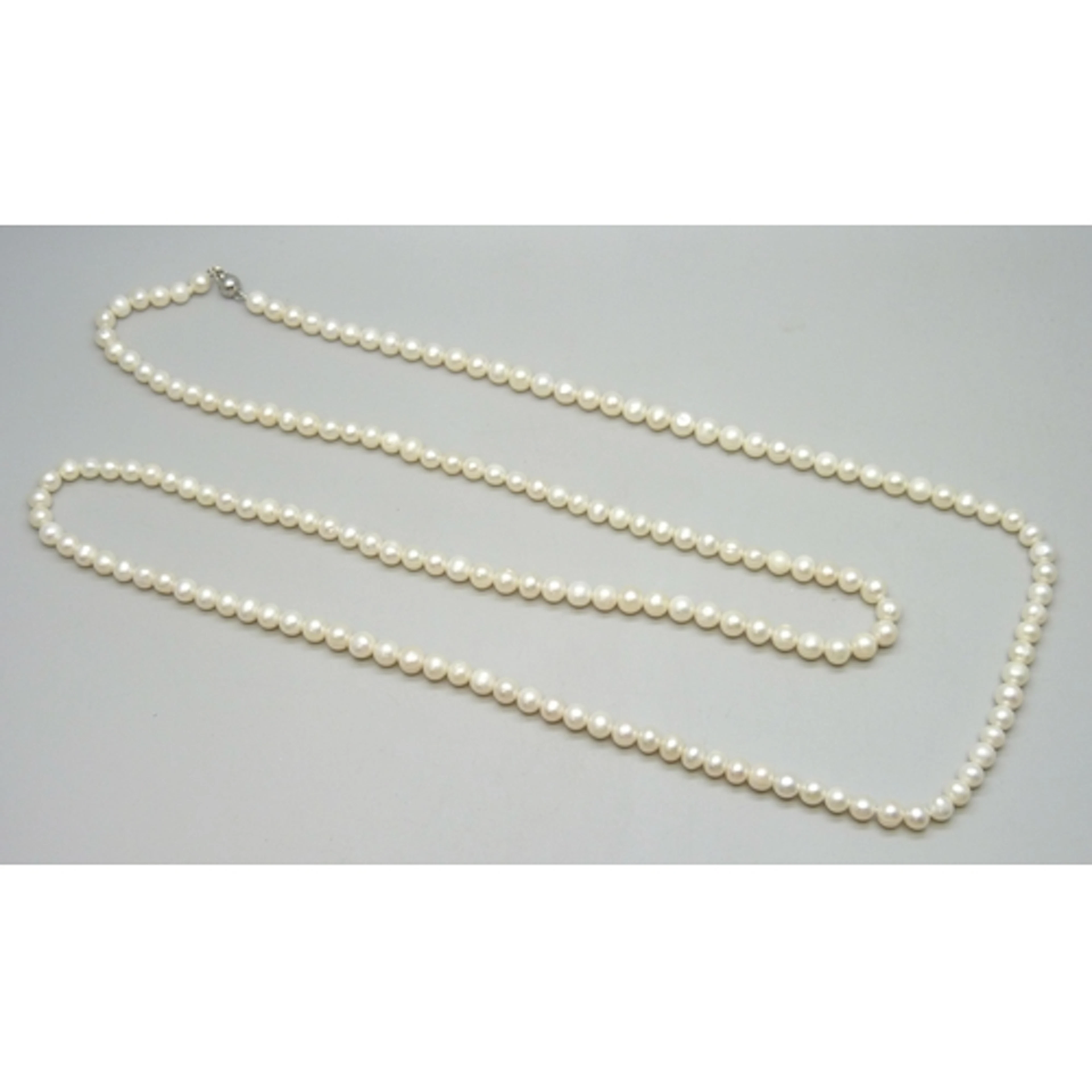 A long opera length pearl necklace with an 18k gold filled c...