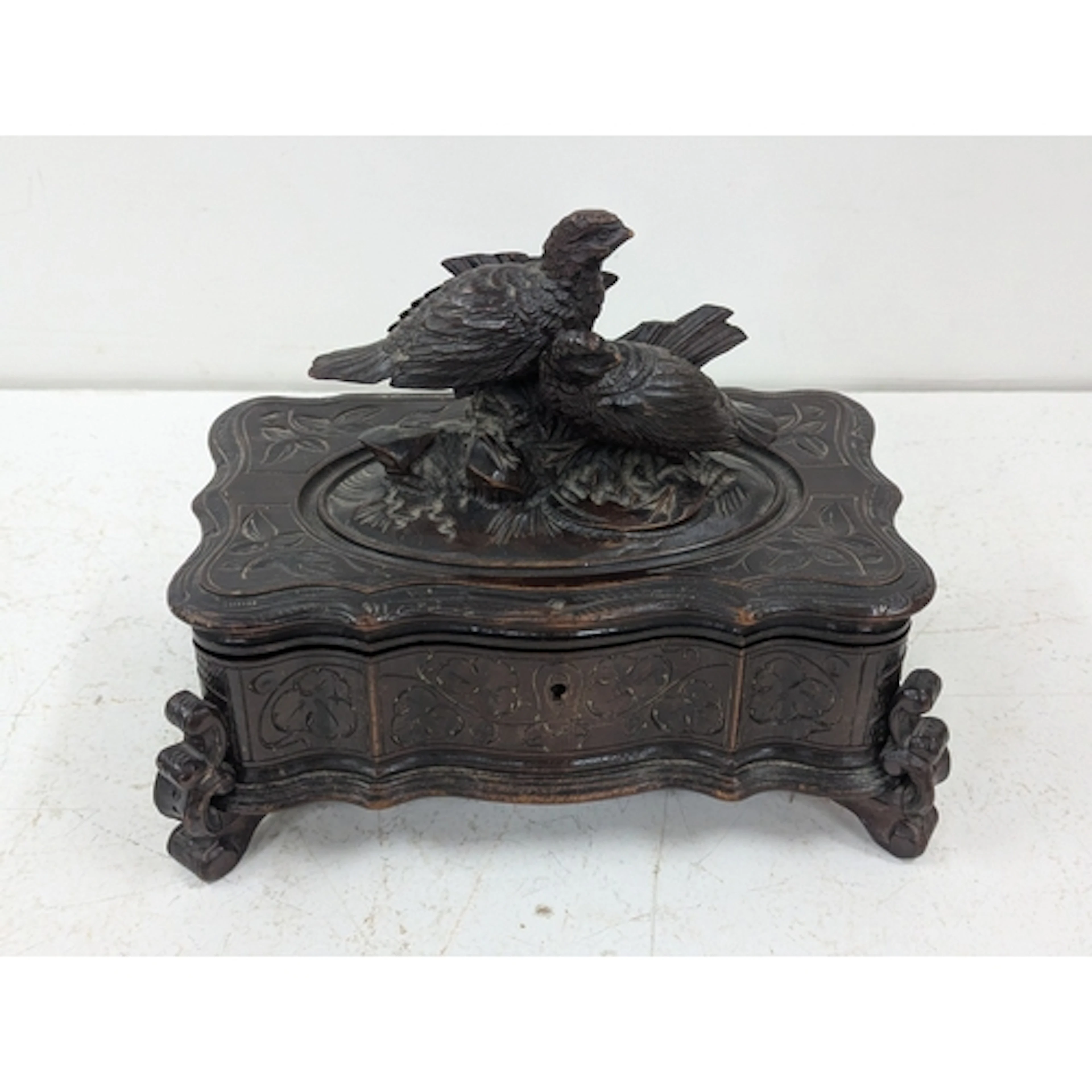 A Black Forest style, dark wooden table box, decorated with ...