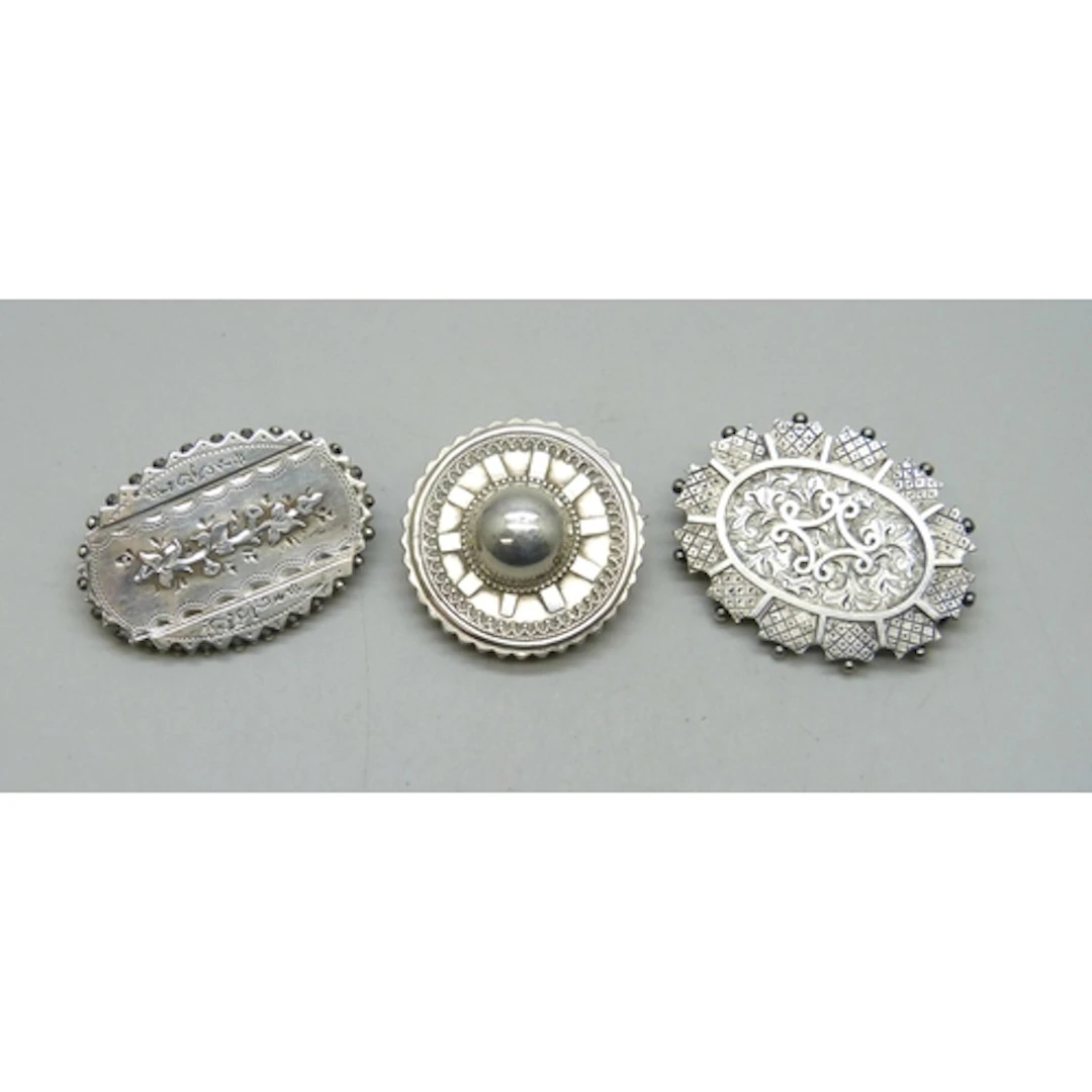 Victorian brooches - Two white metal examples and a silver e...
