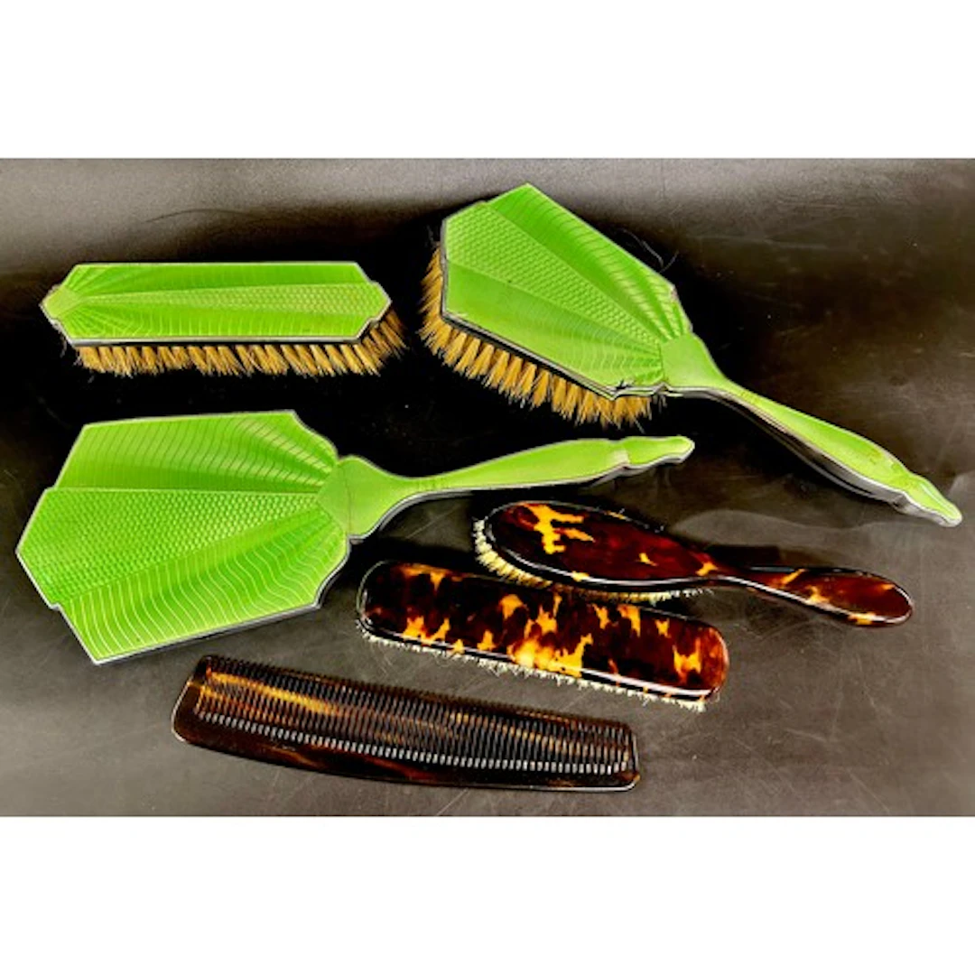 An enamelled Art Deco hand mirror, two matching brushes, etc...