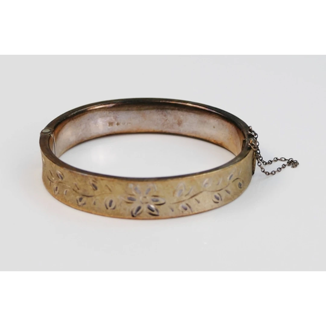 A silver bangle with chased foliate decoration, approx. 61mm...
