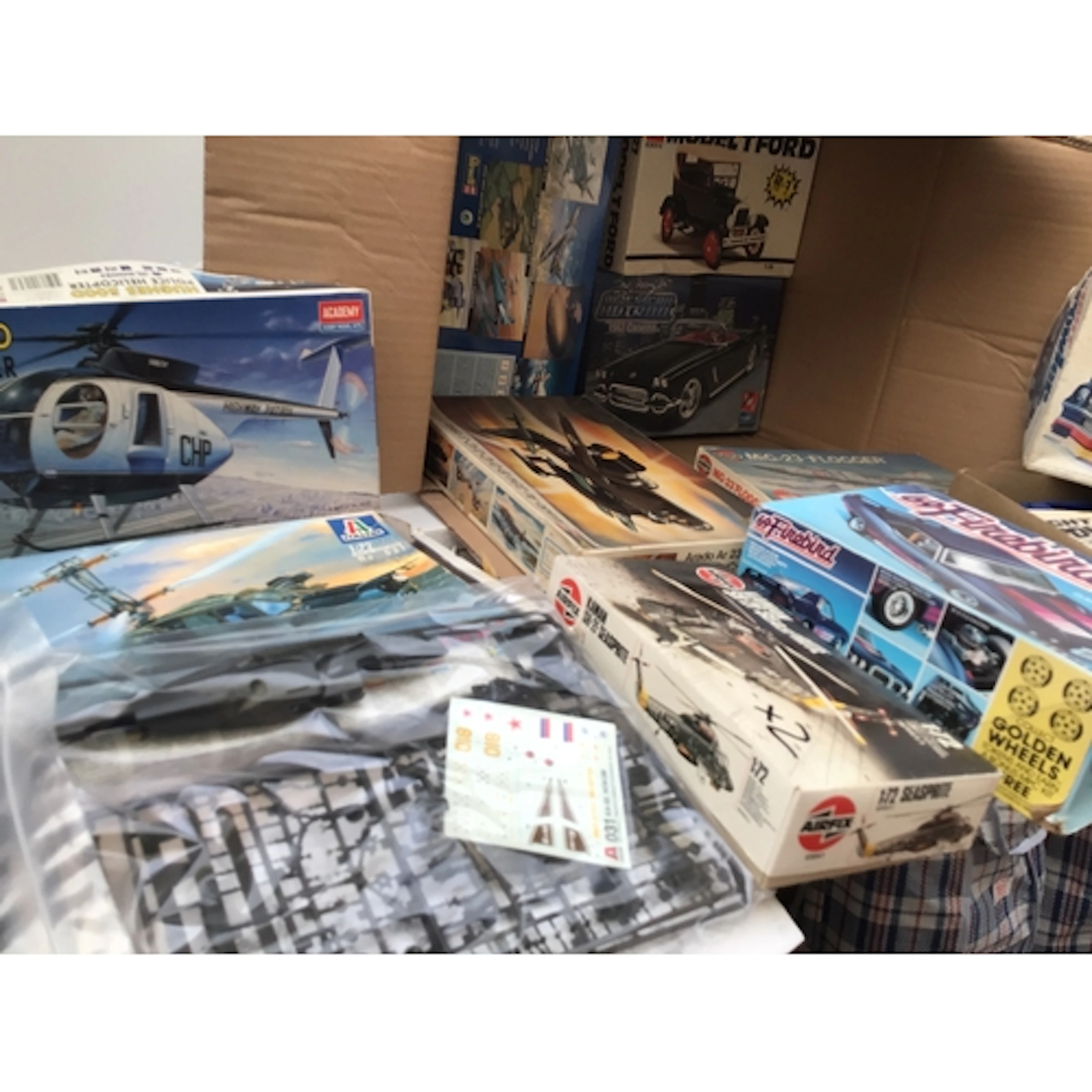 A box containing a collection of boxed model kits featuring ...