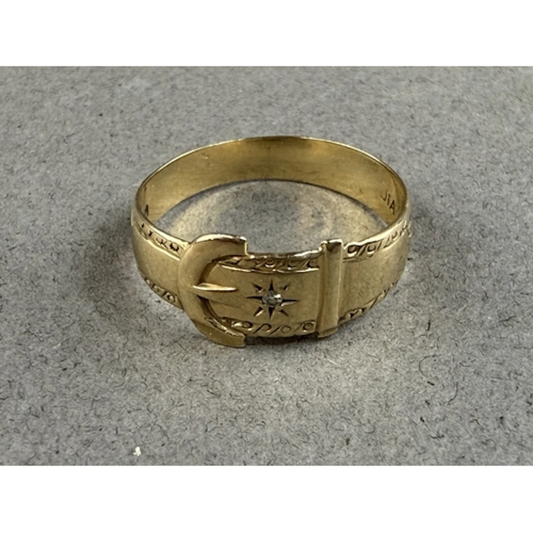 Jewellery: a 9ct yellow gold buckle ring set with a single s...