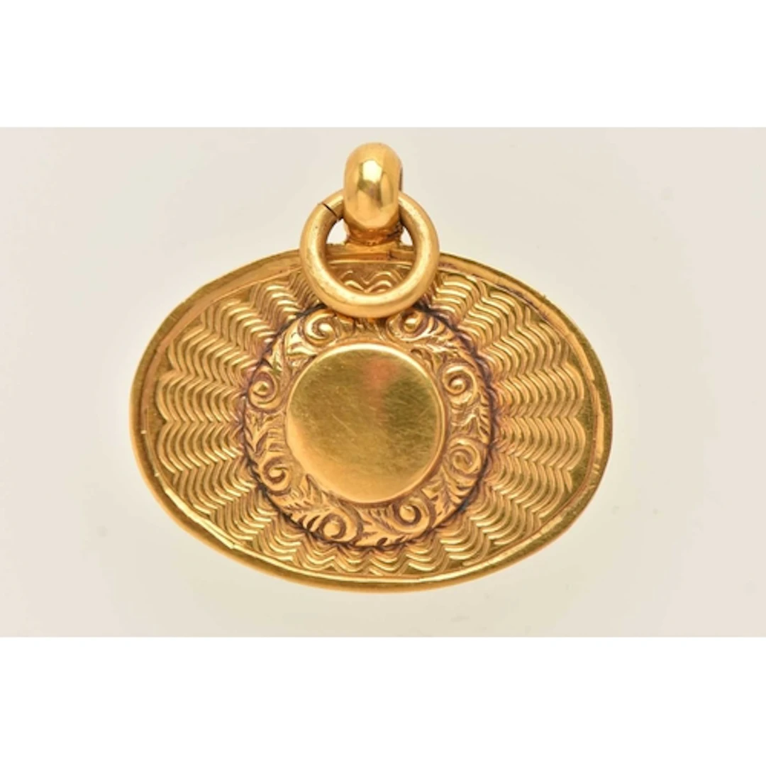 A 9CT YELLOW GOLD PENDANT, an oval form pendant with a circu...