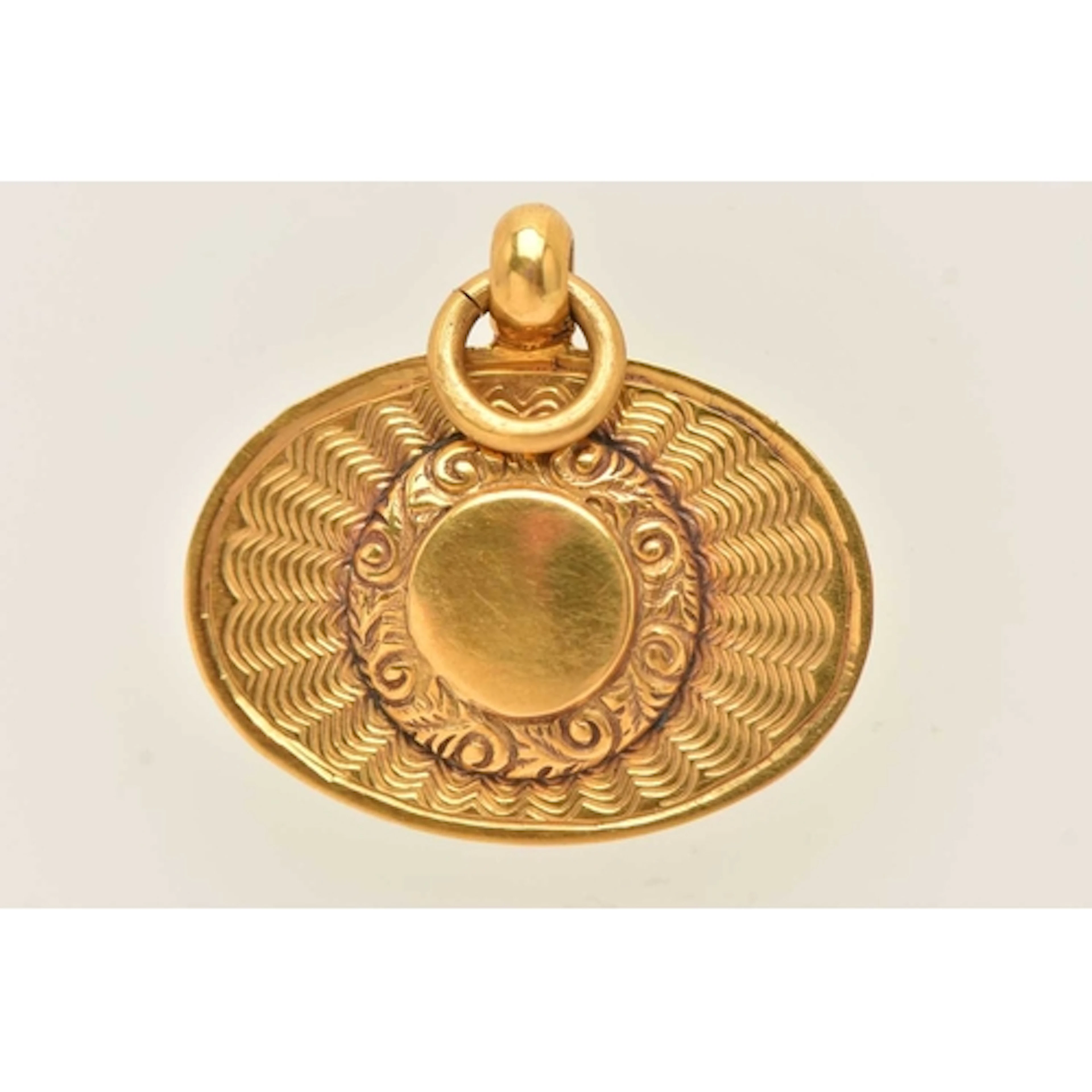 A 9CT YELLOW GOLD PENDANT, an oval form pendant with a circu...