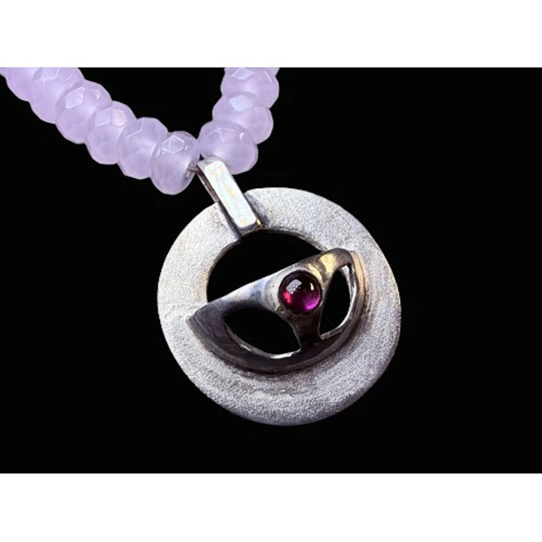 An artisan necklace formed from multi faceted rose quartz be...
