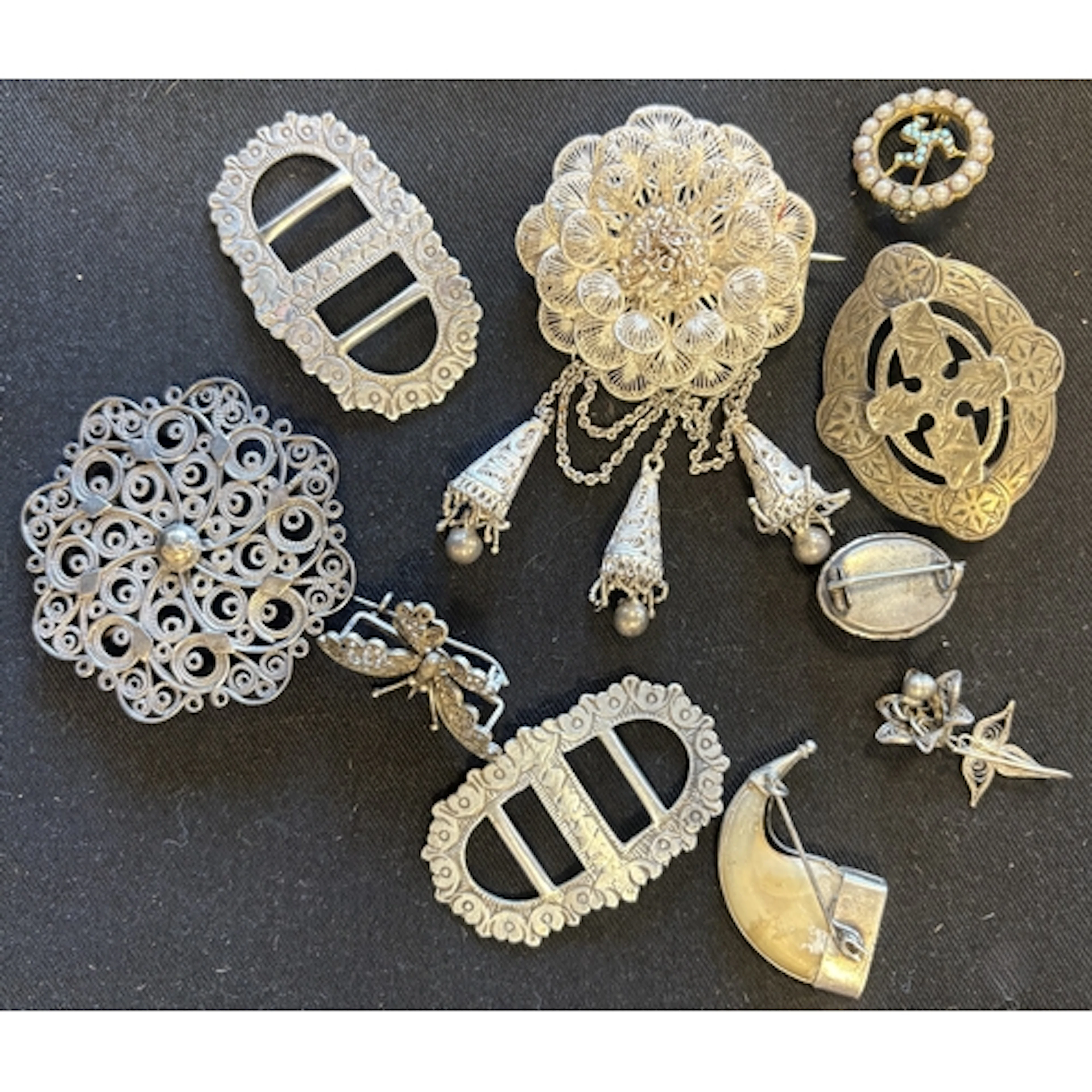 A small collection of filigree silver brooches, buckles etc....