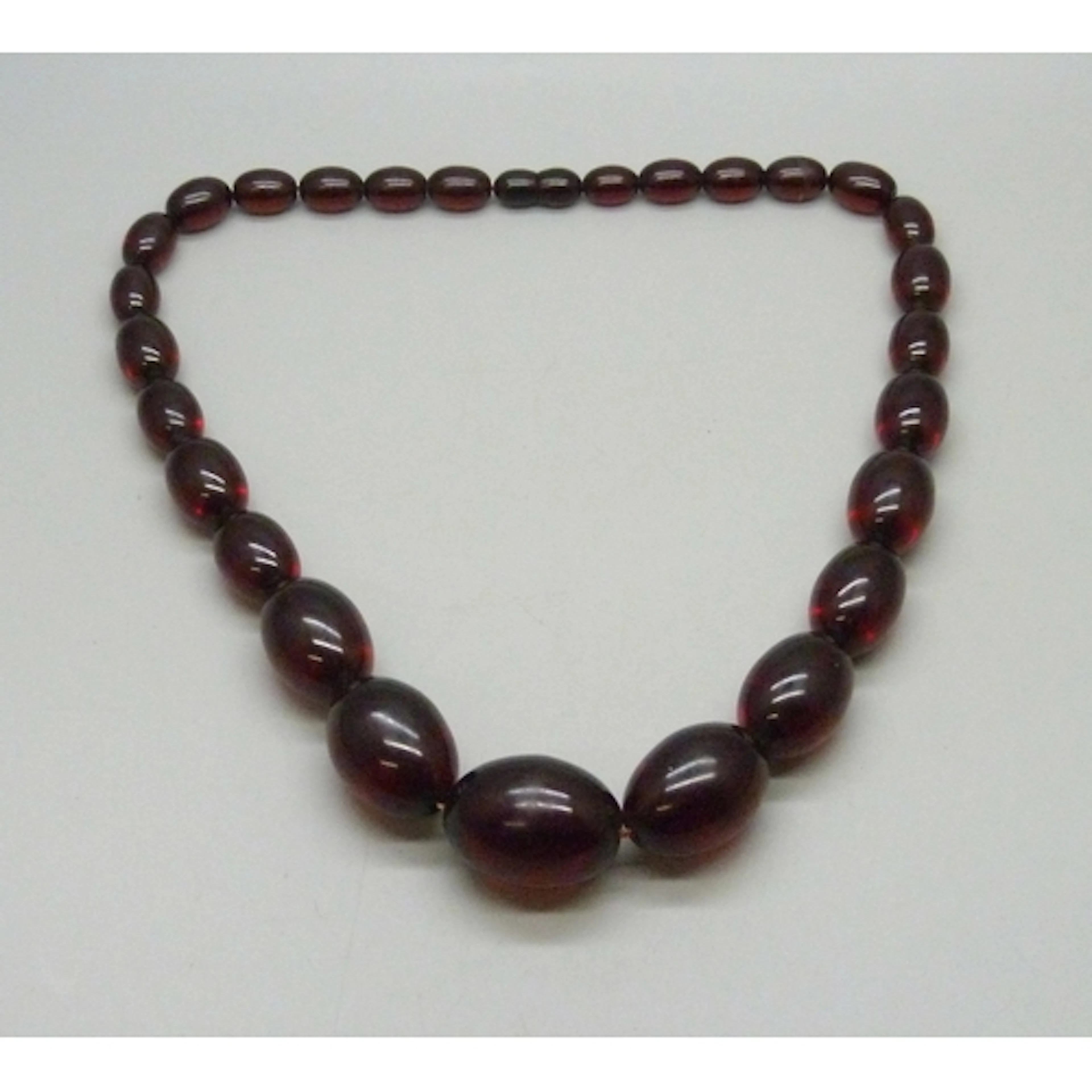 A string of cherry amber coloured beads, tests as Bakelite, ...
