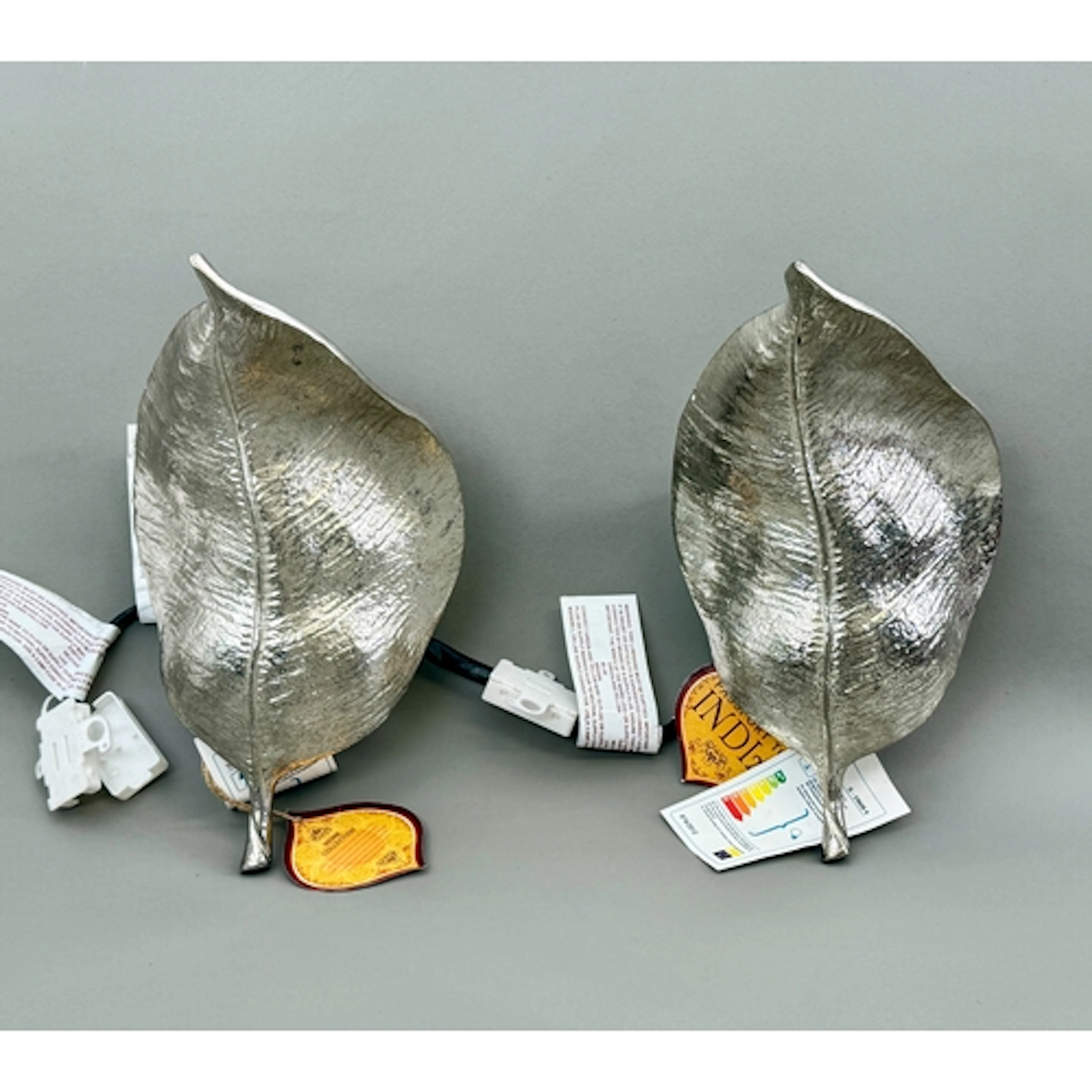 A pair of modern leaf shaped wall sconces - silver tone meta...