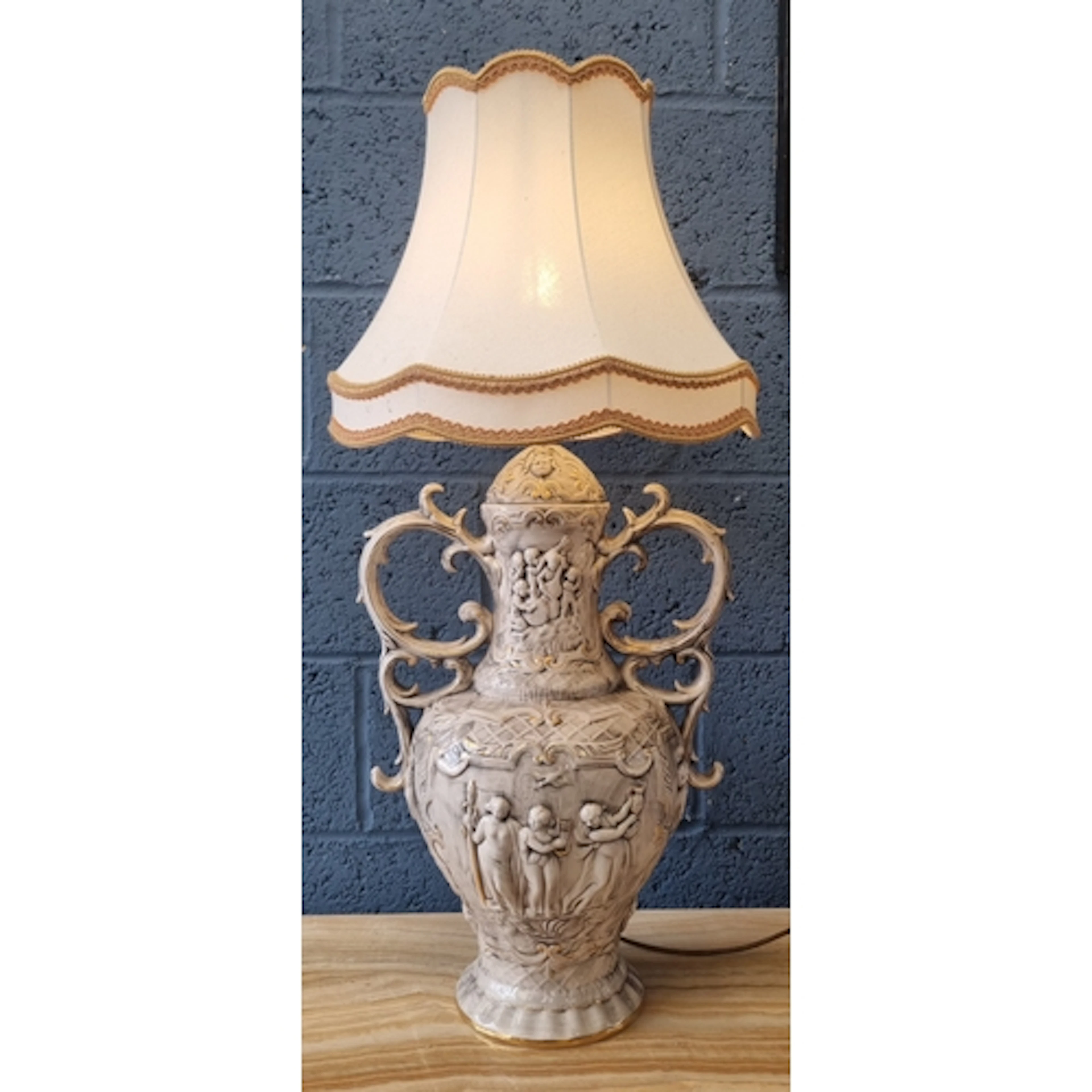 Ornate relief-decorated ceramic table lamp with fabric shade...