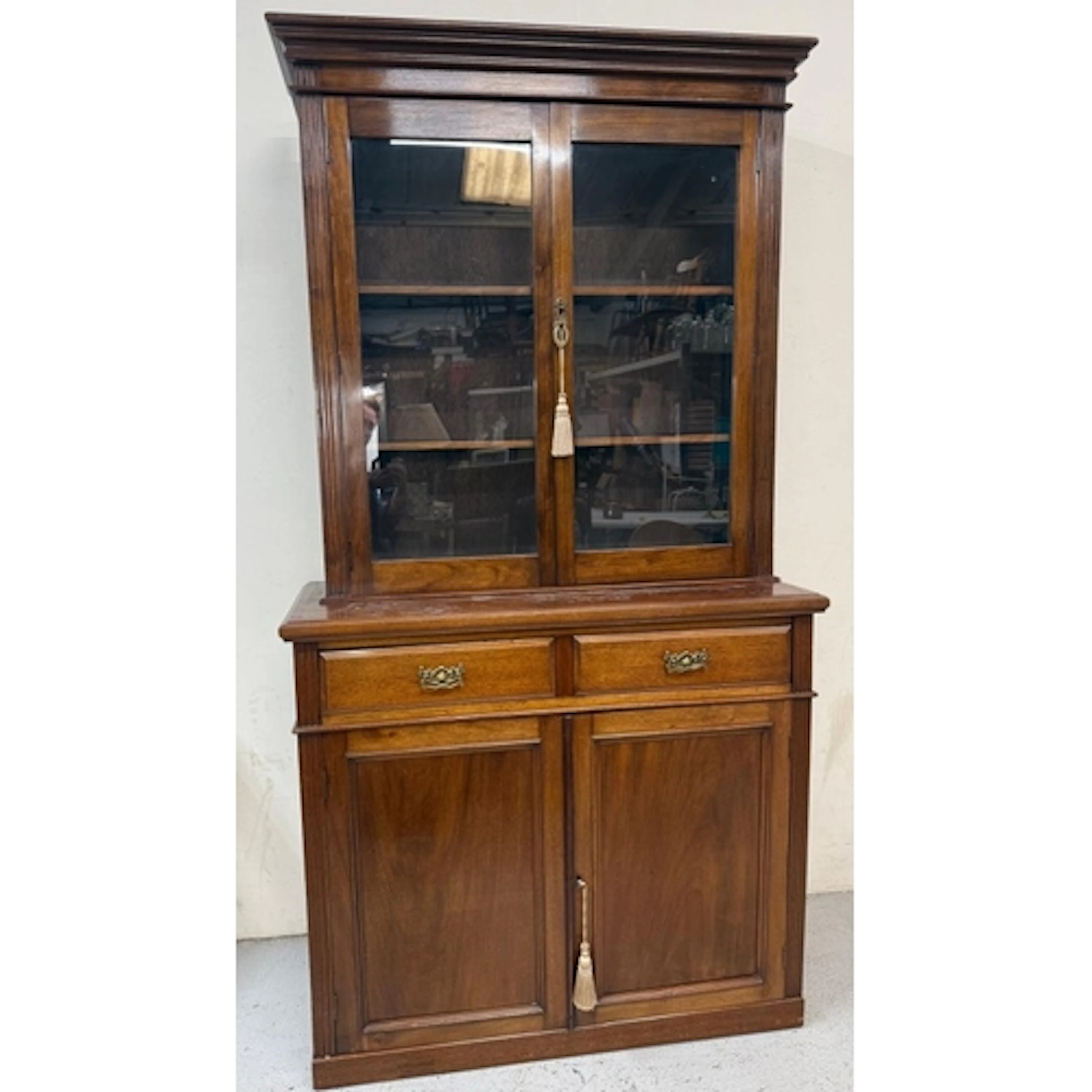 A mahogany glazed library book case over a two drawer two do...