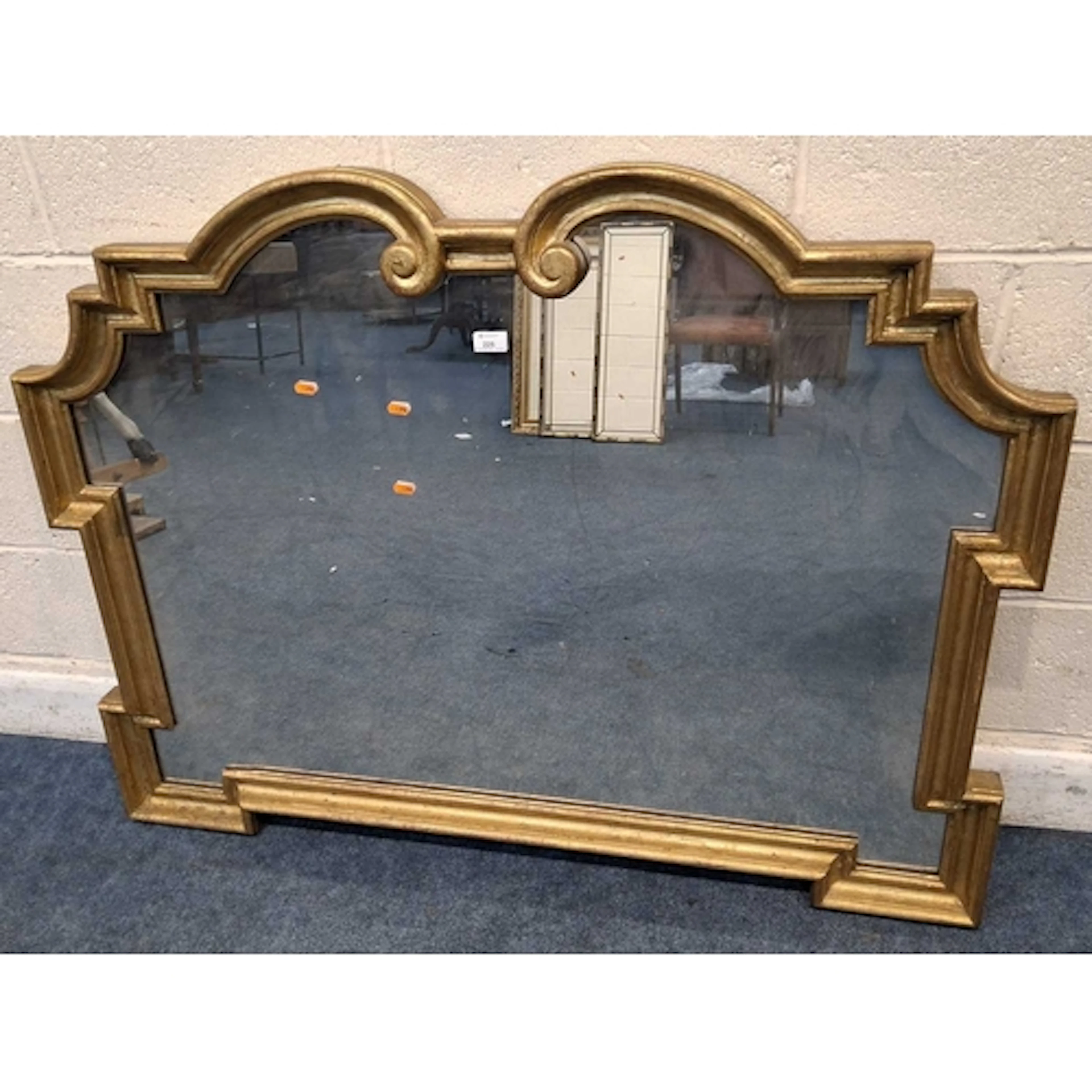 A MODERN GILT FRAME WALL MIRROR, with geometric and scrolled...