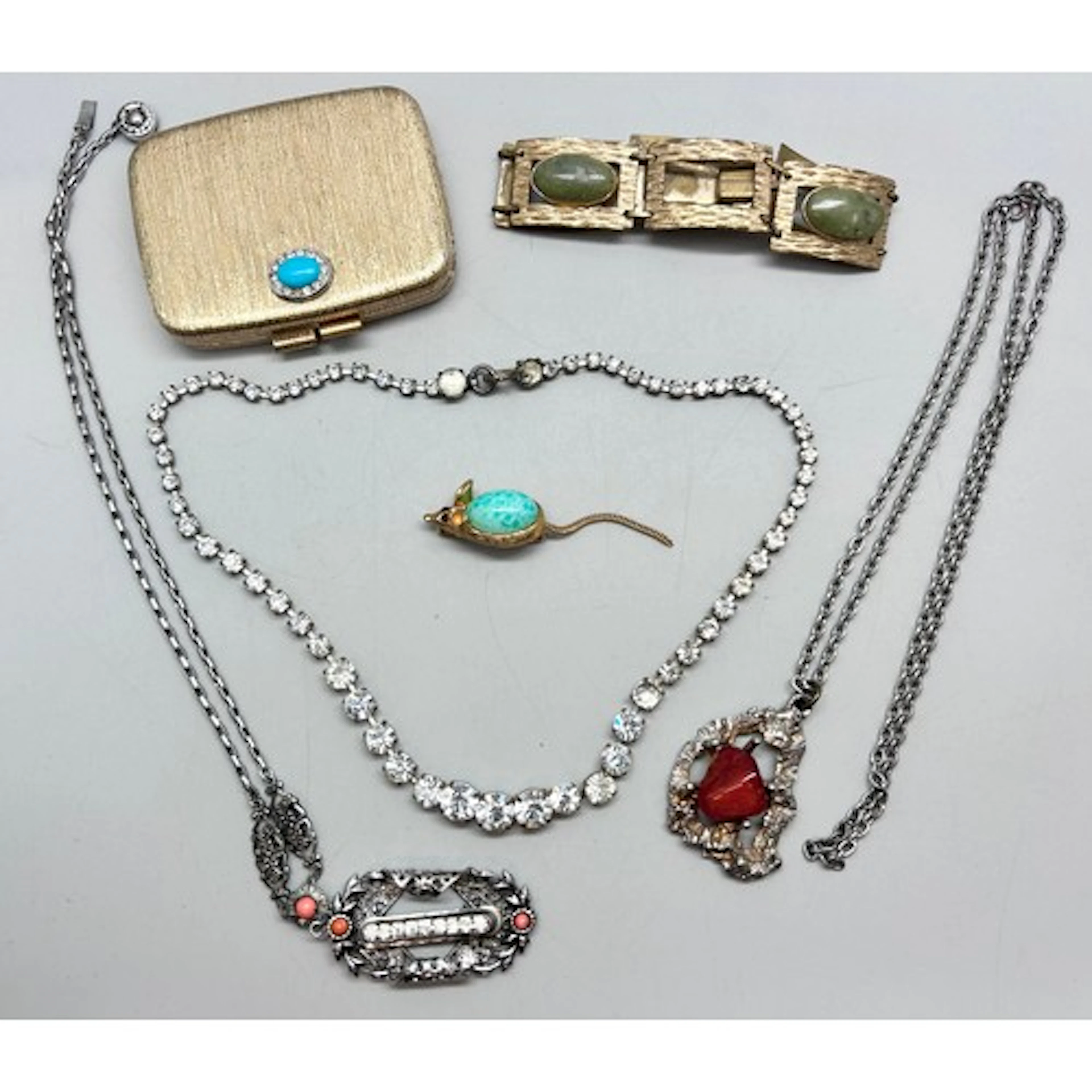 A collection of vintage costume jewellery and a compact