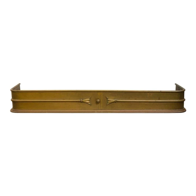A late Victorian brass fender. With a central knob and centr...