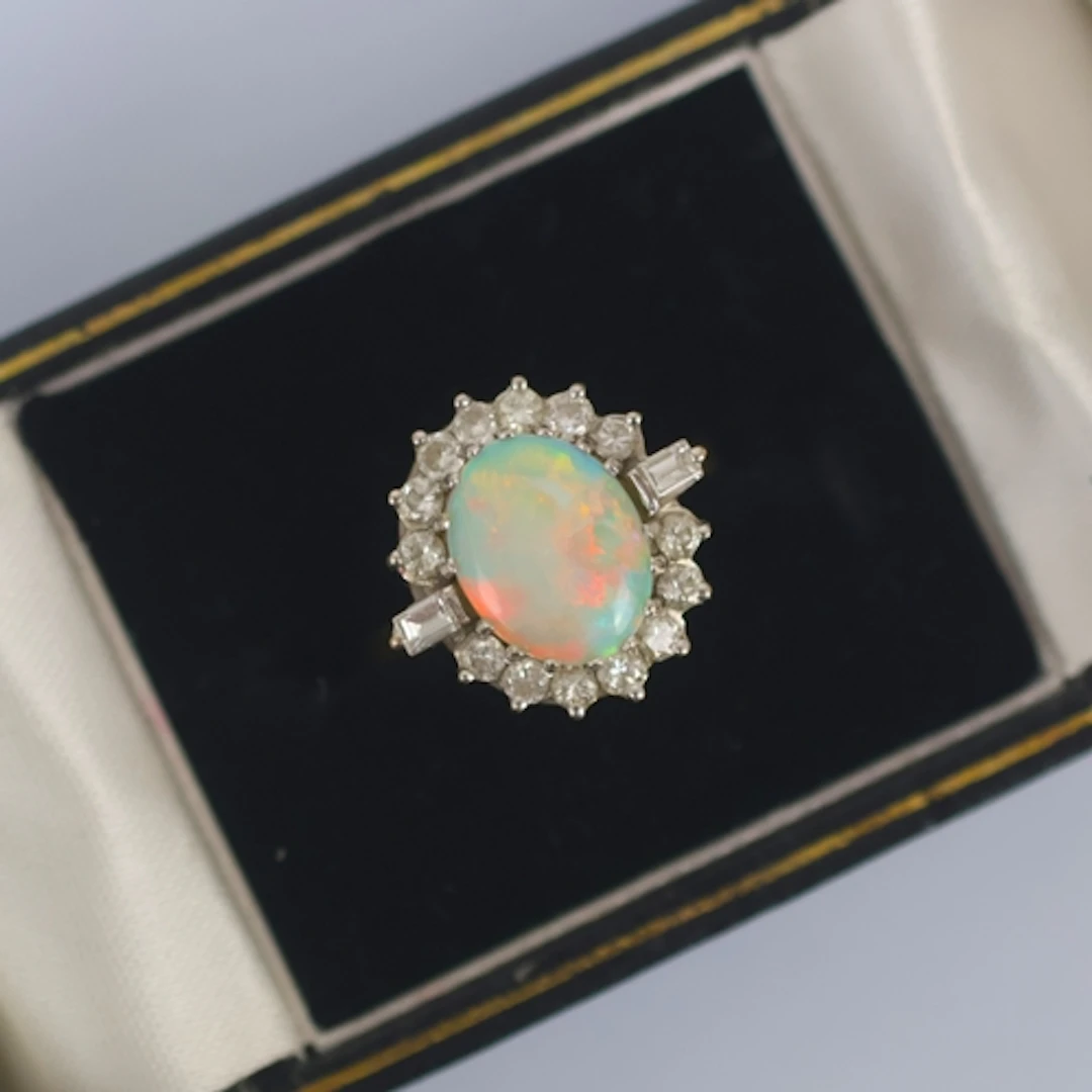 A late 20th century opal and diamond ring, the central oval ...