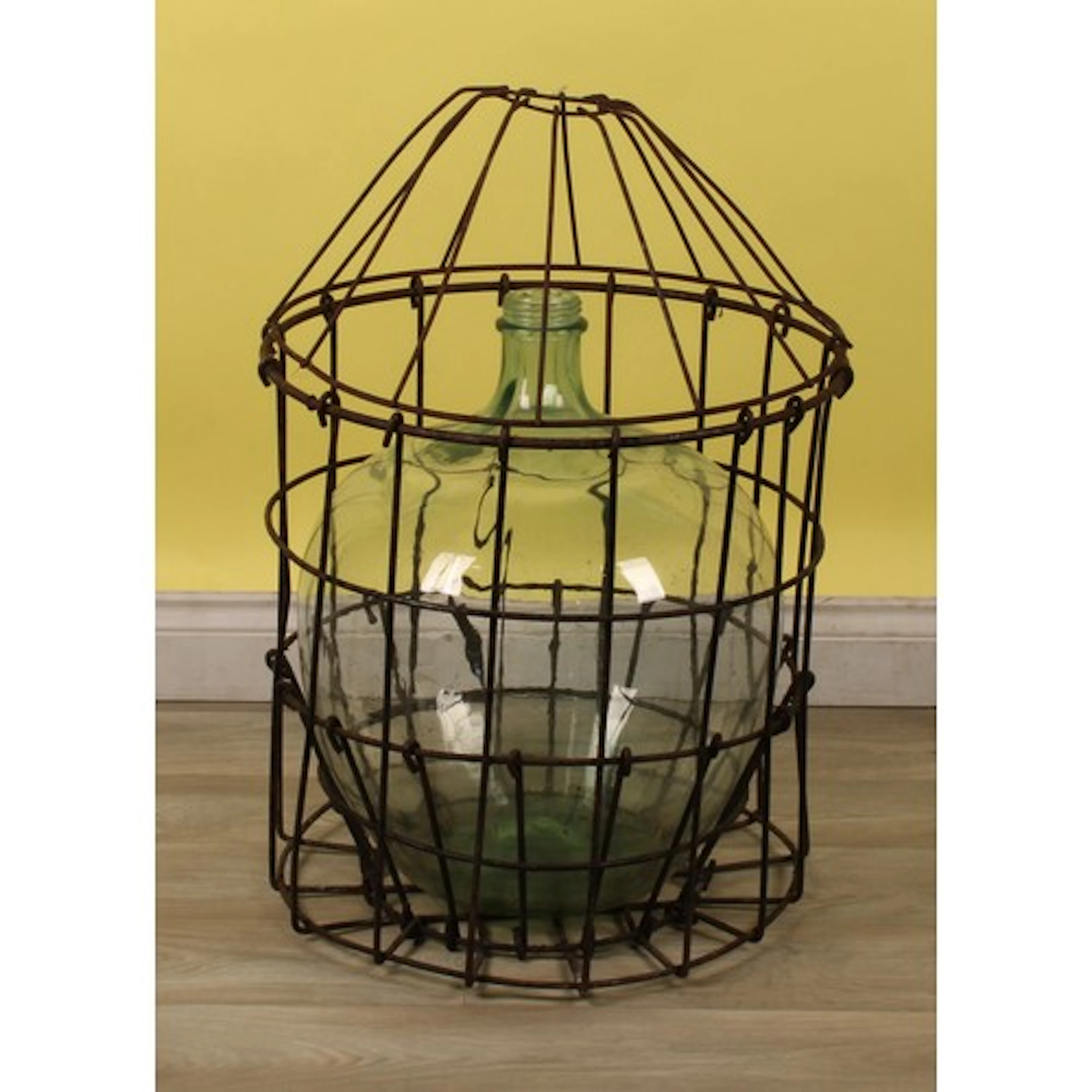A French glass demijohn or carboy, wrought iron cage and cov...