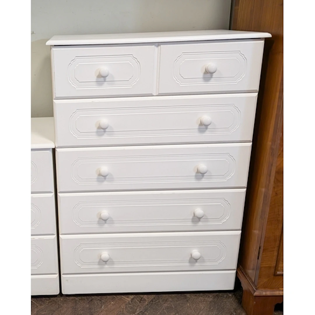 A modern white chest of five long drawers with bun handles, ...