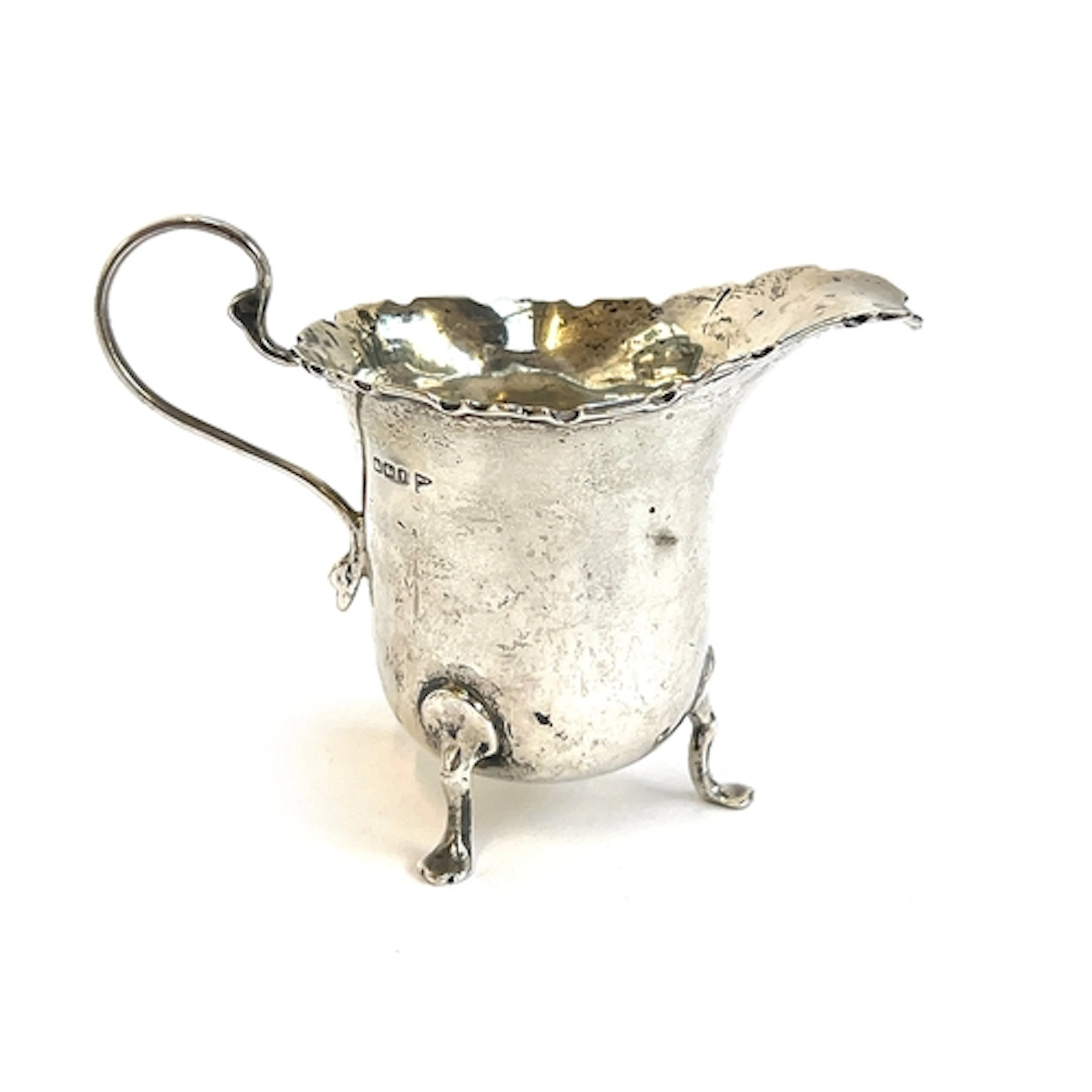 A small silver cream jug with shaped edge by Walker & Hall, ...
