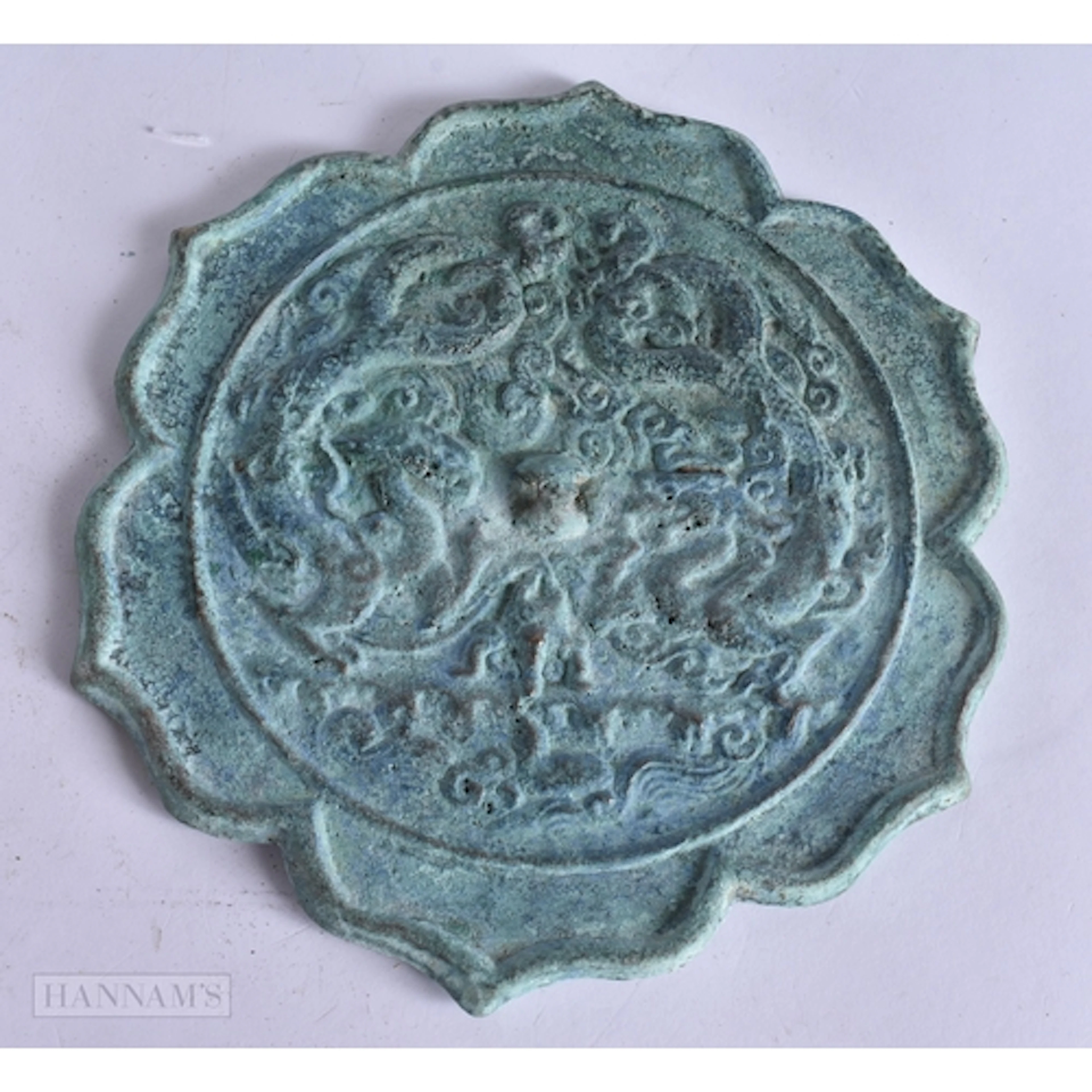A CHINESE SILVERED BRONZE MIRROR with barbed rim and dragon ...