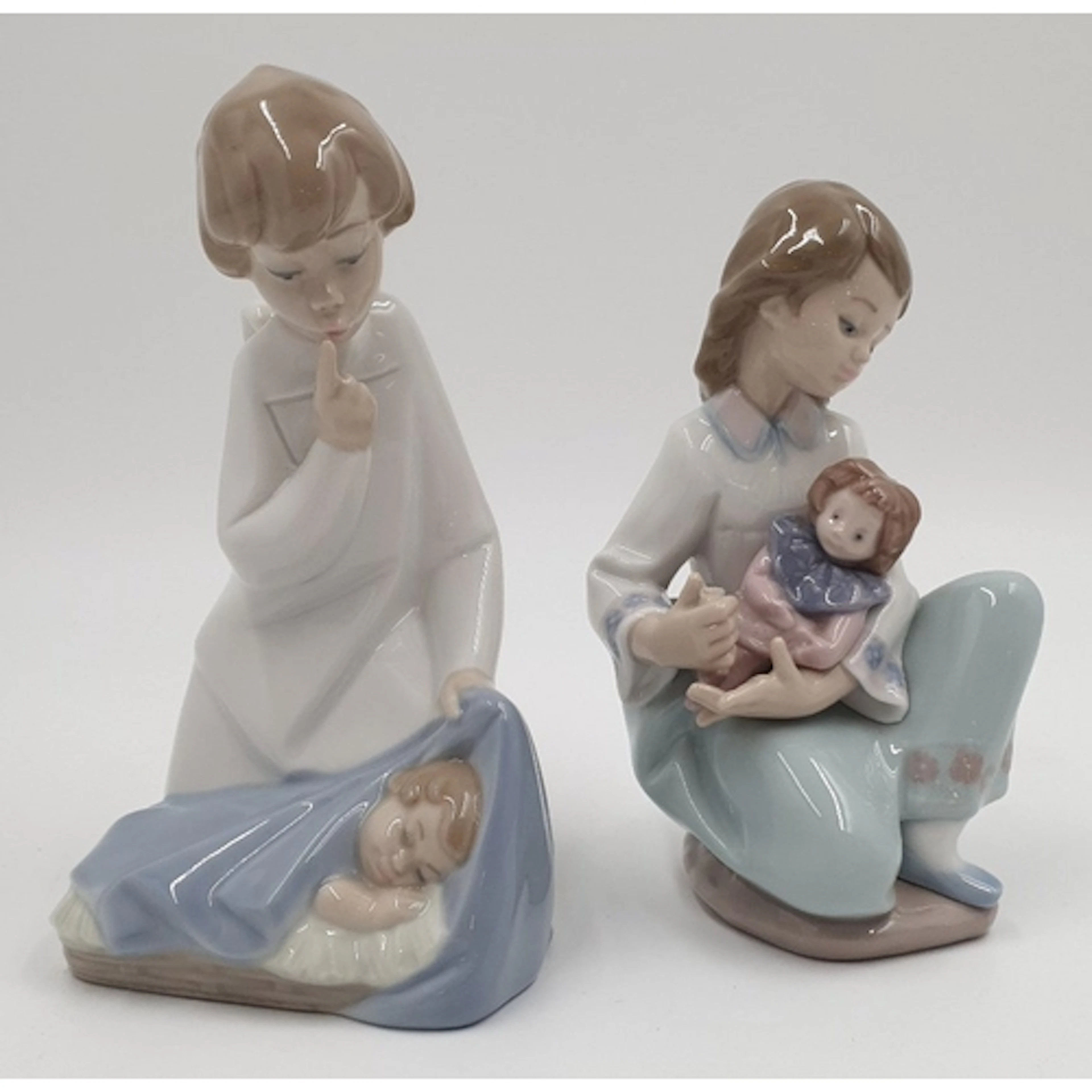 Lot of 2x Lladro porcelain figures comprising a child beside...