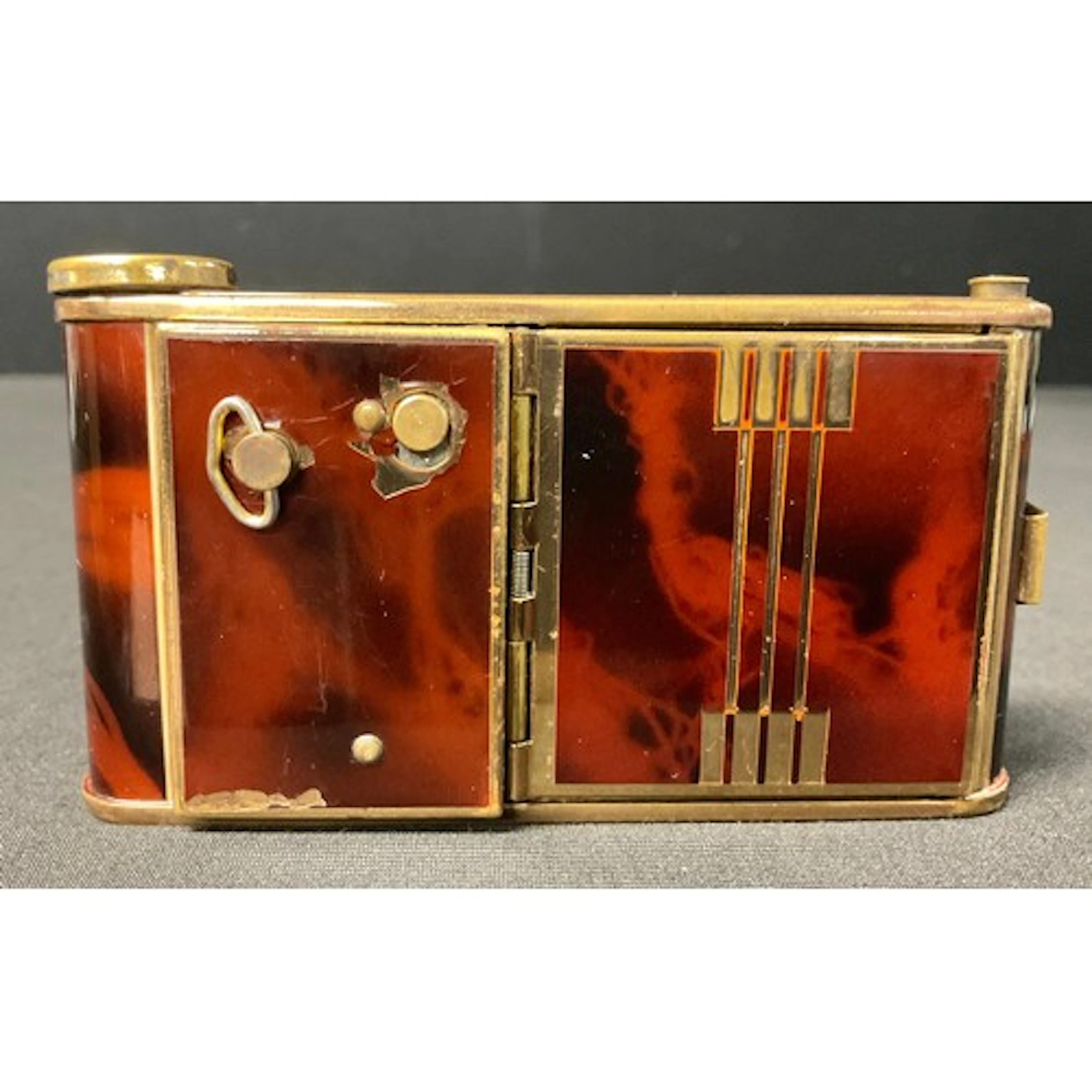 An Art Deco compact, in the style of a camera, decorated wit...