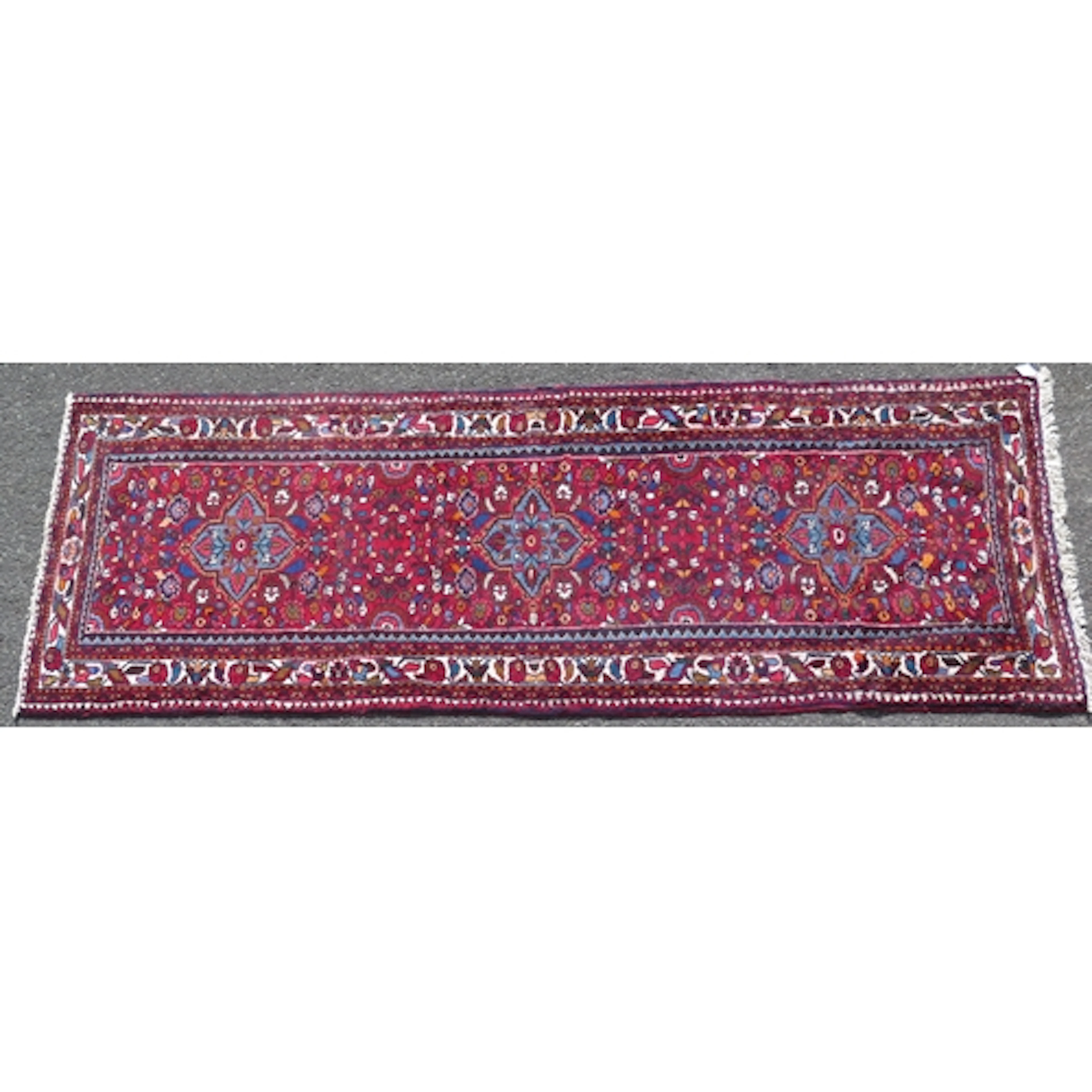 A Persian design runner, the wine red field with single row ...