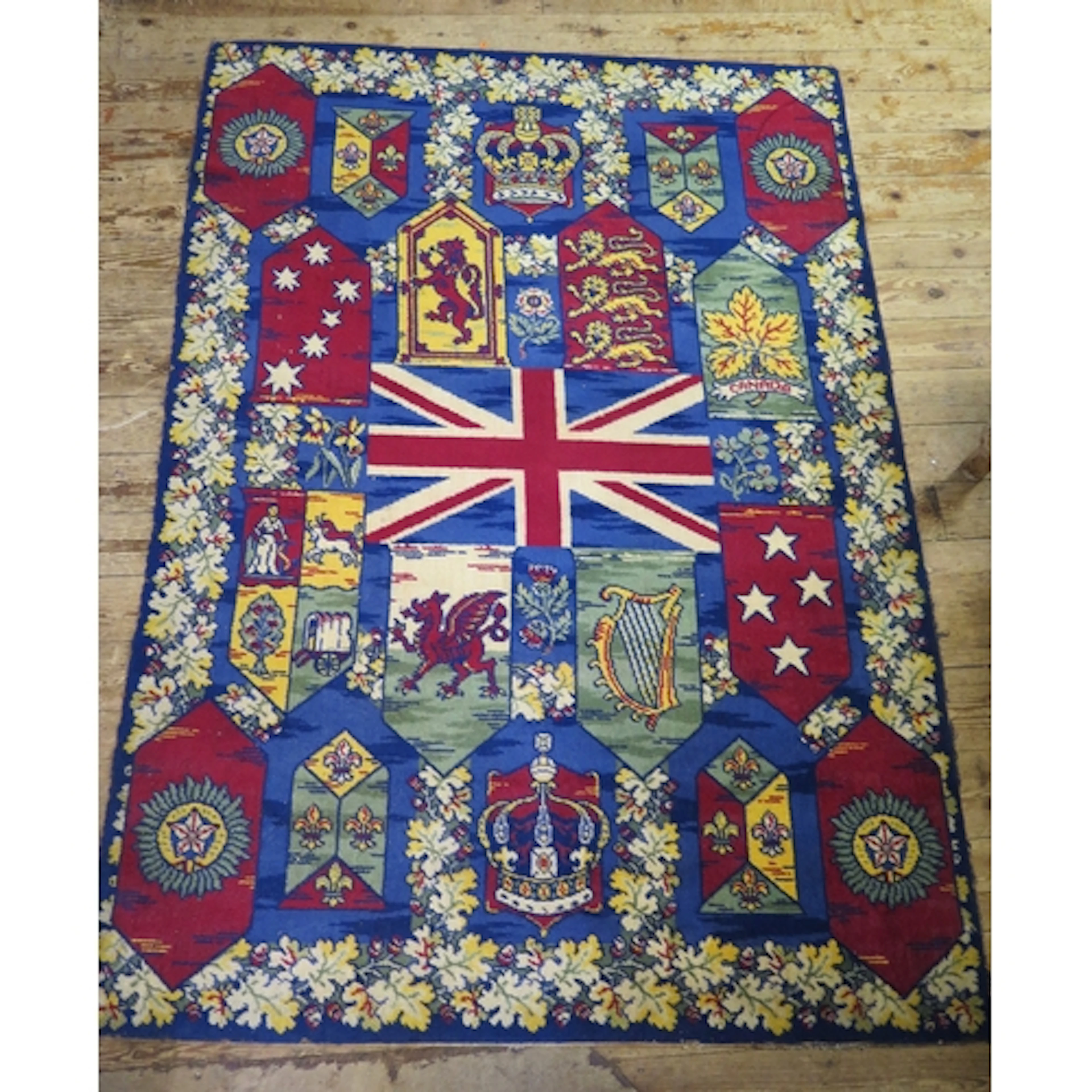 A machine woven rug, with central union flag, national embl...
