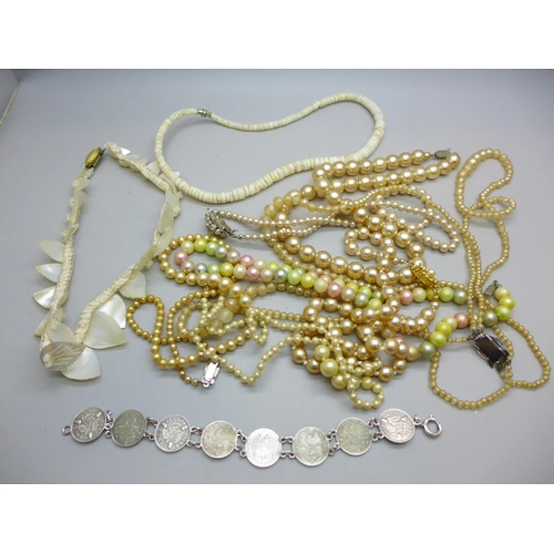 A collection of faux pearl necklaces, a mother of pearl neck...