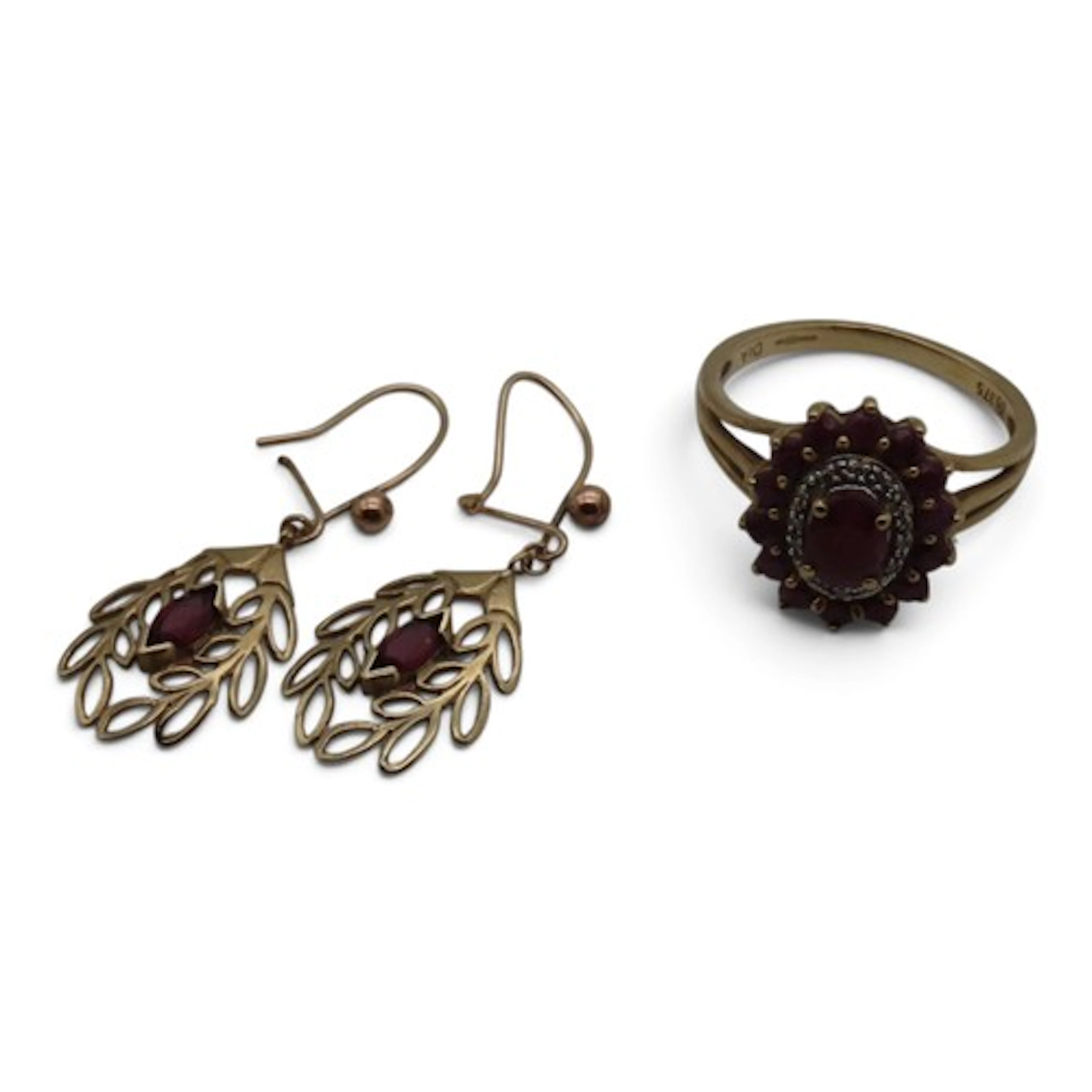 A ruby and diamond cluster ring, centred with an oval mixed-...