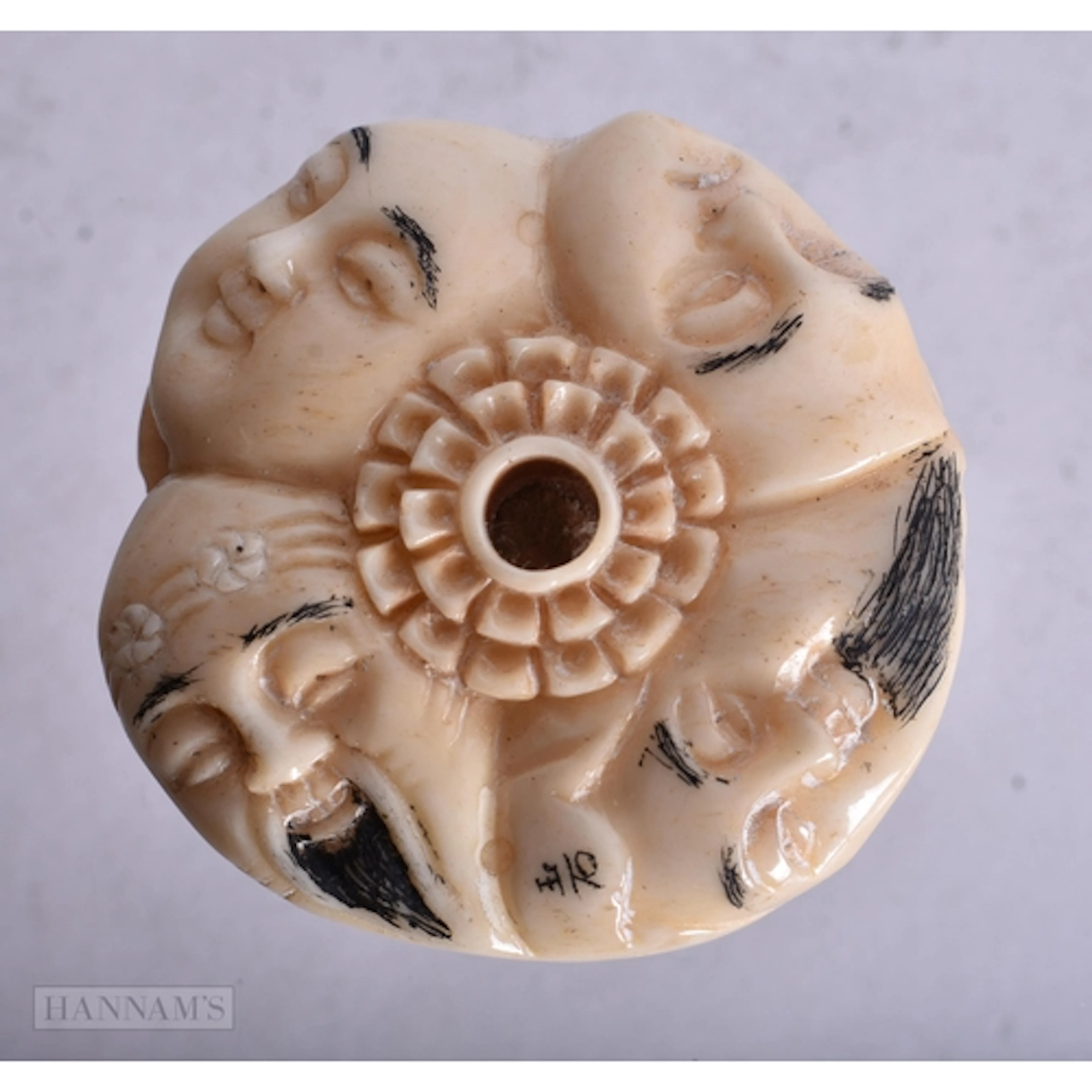 A BONE IMMORTAL FACES NETSUKE. 4.2 x 1.7 cm