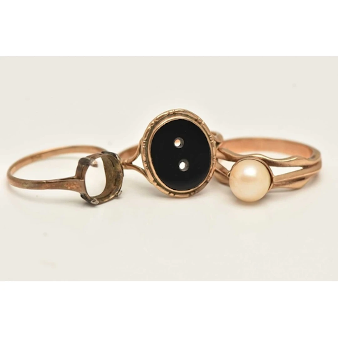 THREE YELLOW METAL RINGS, the first an onyx signet missing i...