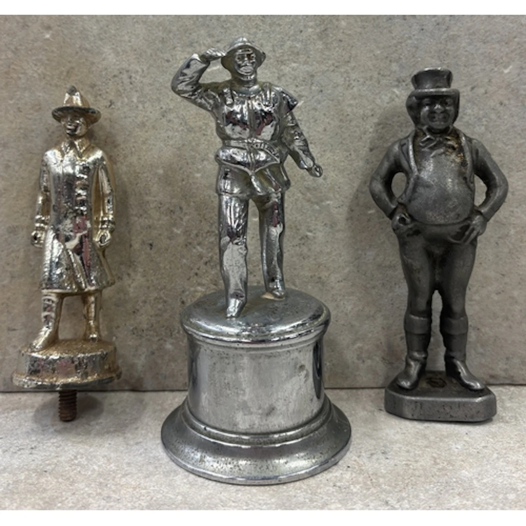 A collection of three figural bonnet mascots including a Lif...