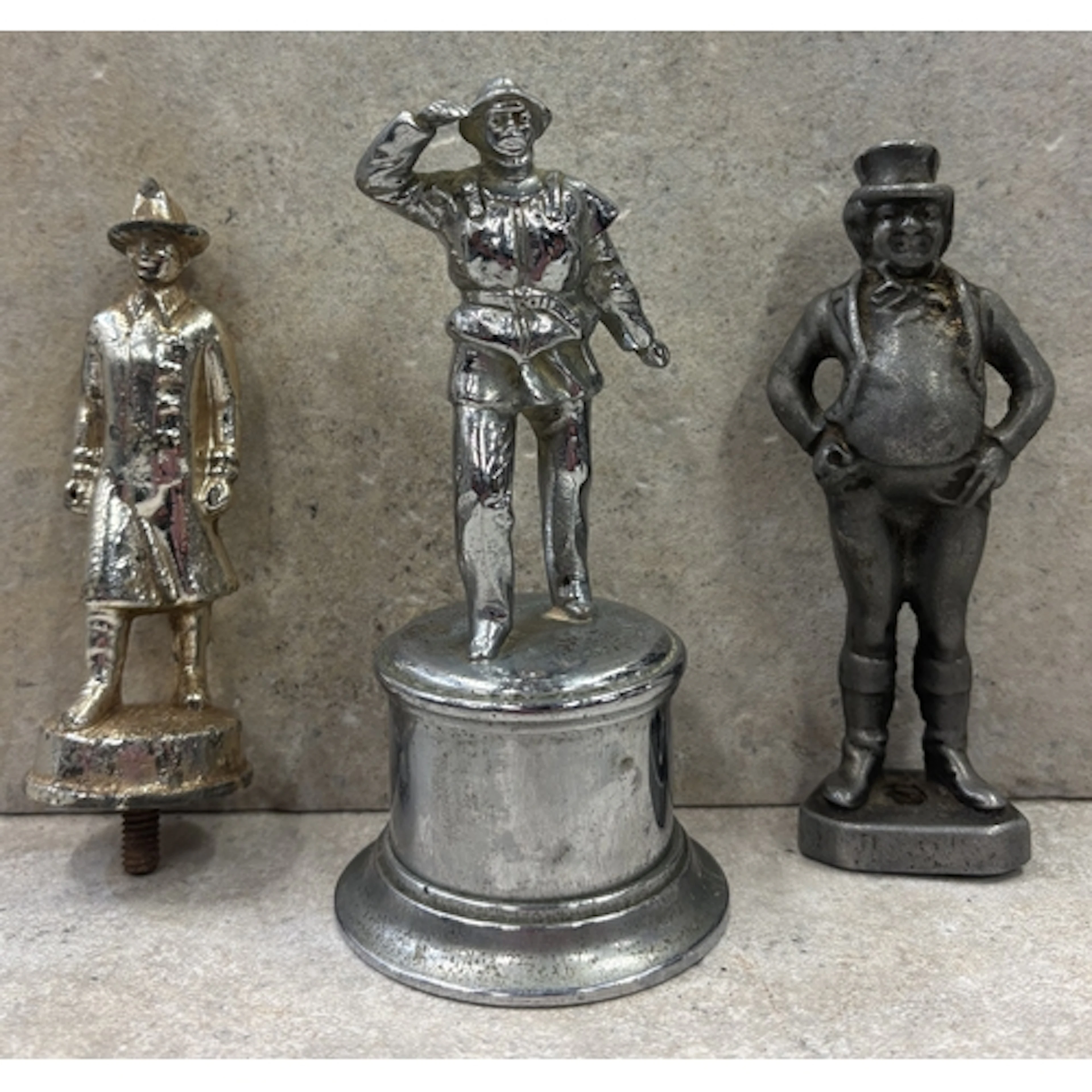 A collection of three figural bonnet mascots including a Lif...