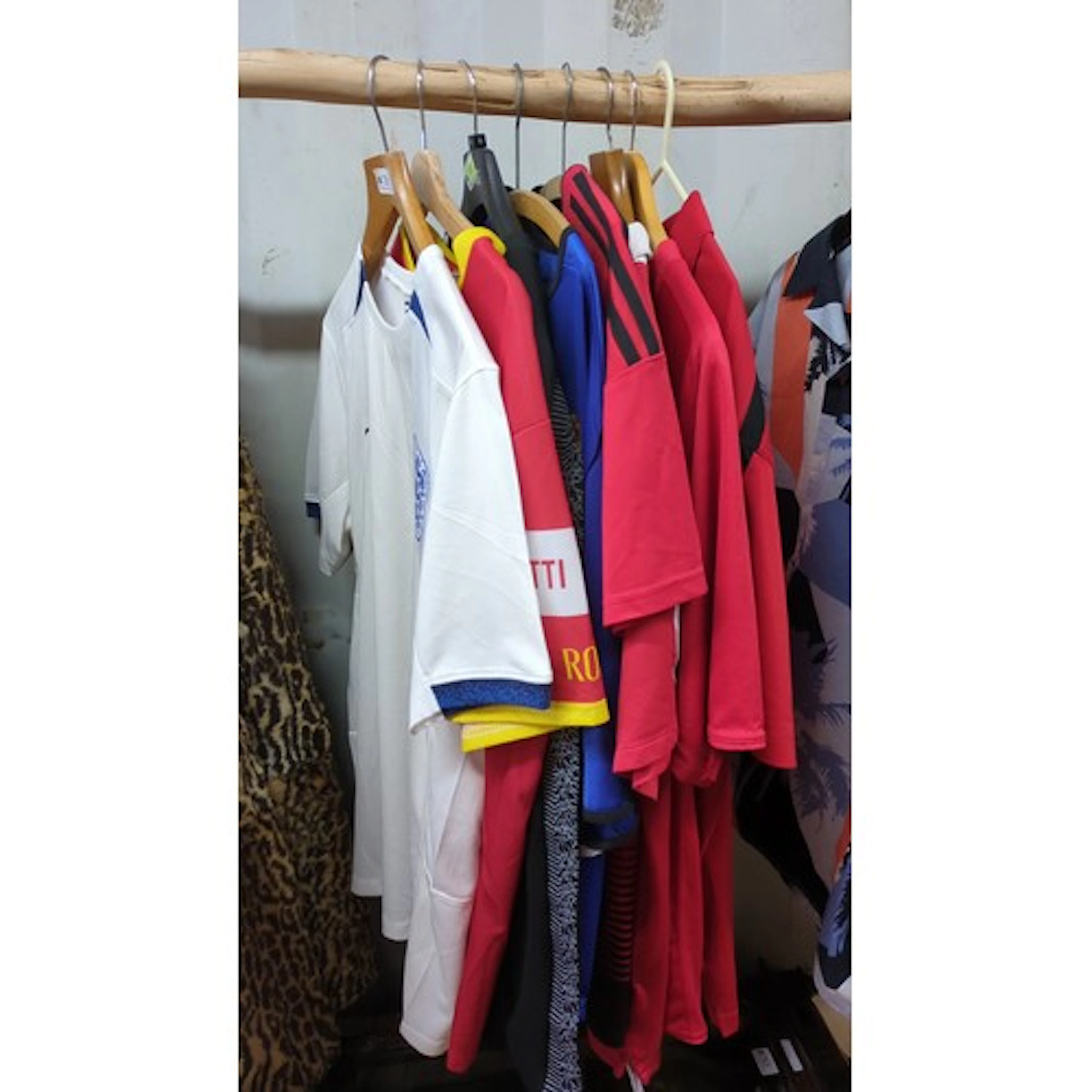 A group of modern football shirts and training tops, includi...