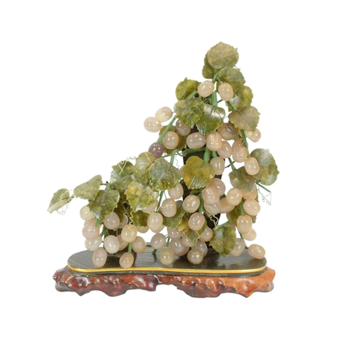 A Chinese hardstone vine. On a hardwood and hardstone base, ...