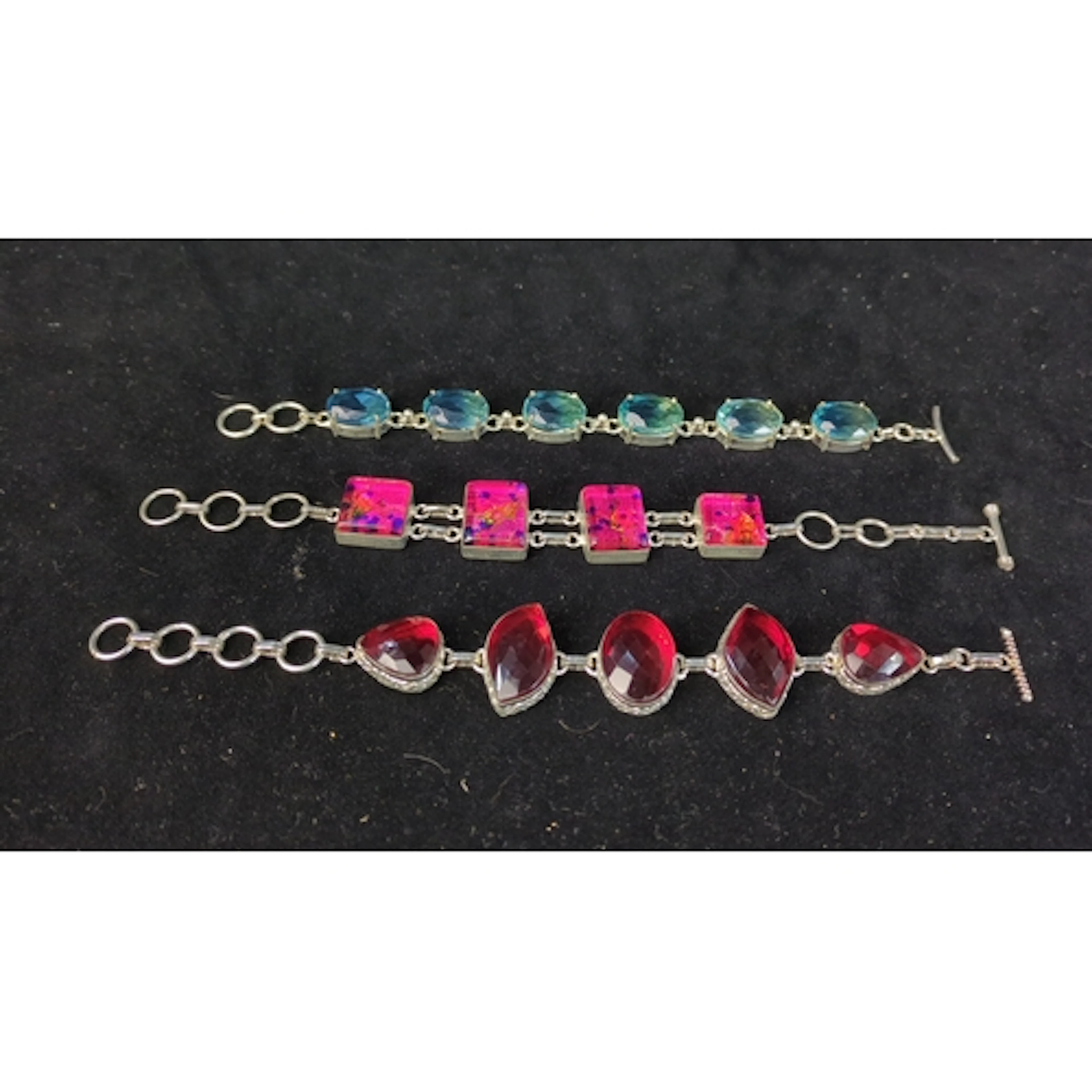 A group of three silver bracelets set respectively with face...
