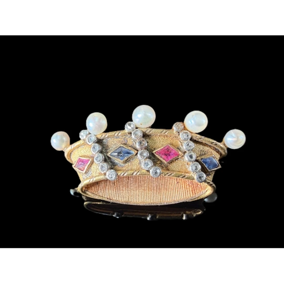 A yellow metal brooch in the form of a crown set with rubies...