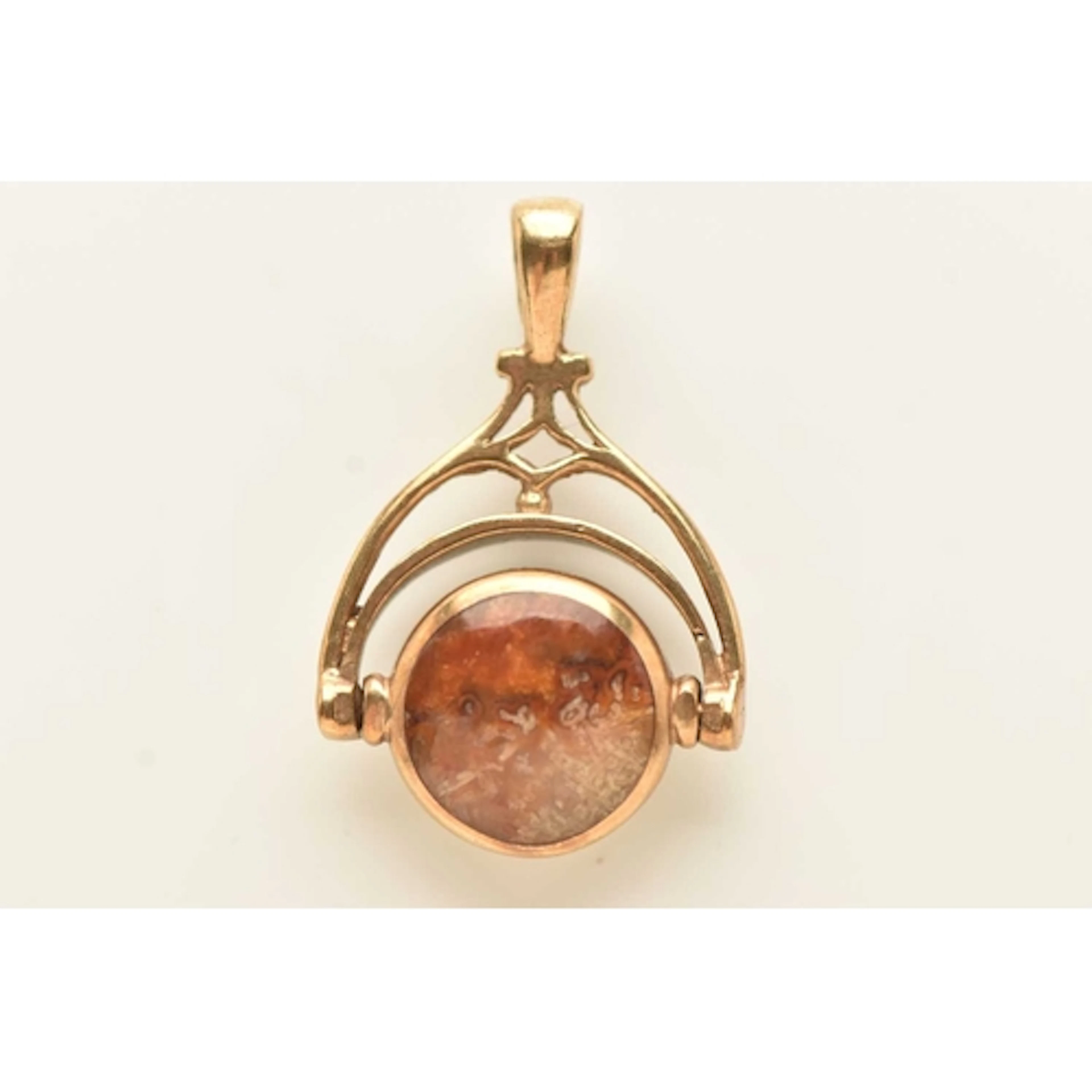 A 9CT GOLD GEM SET SWIVEL PENDANT, of a circular form set wi...