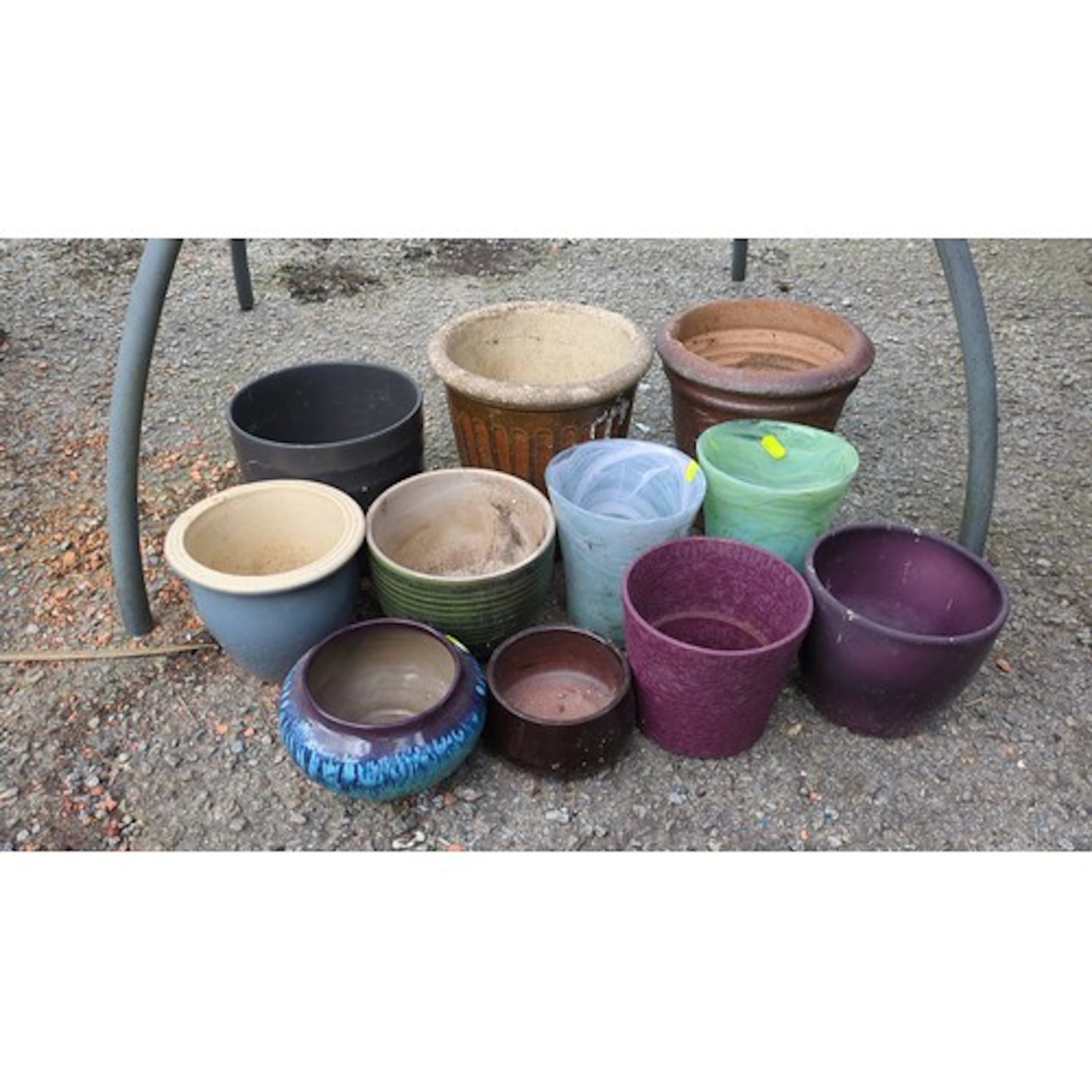 A group of garden planters, including cylindrical plastic po...
