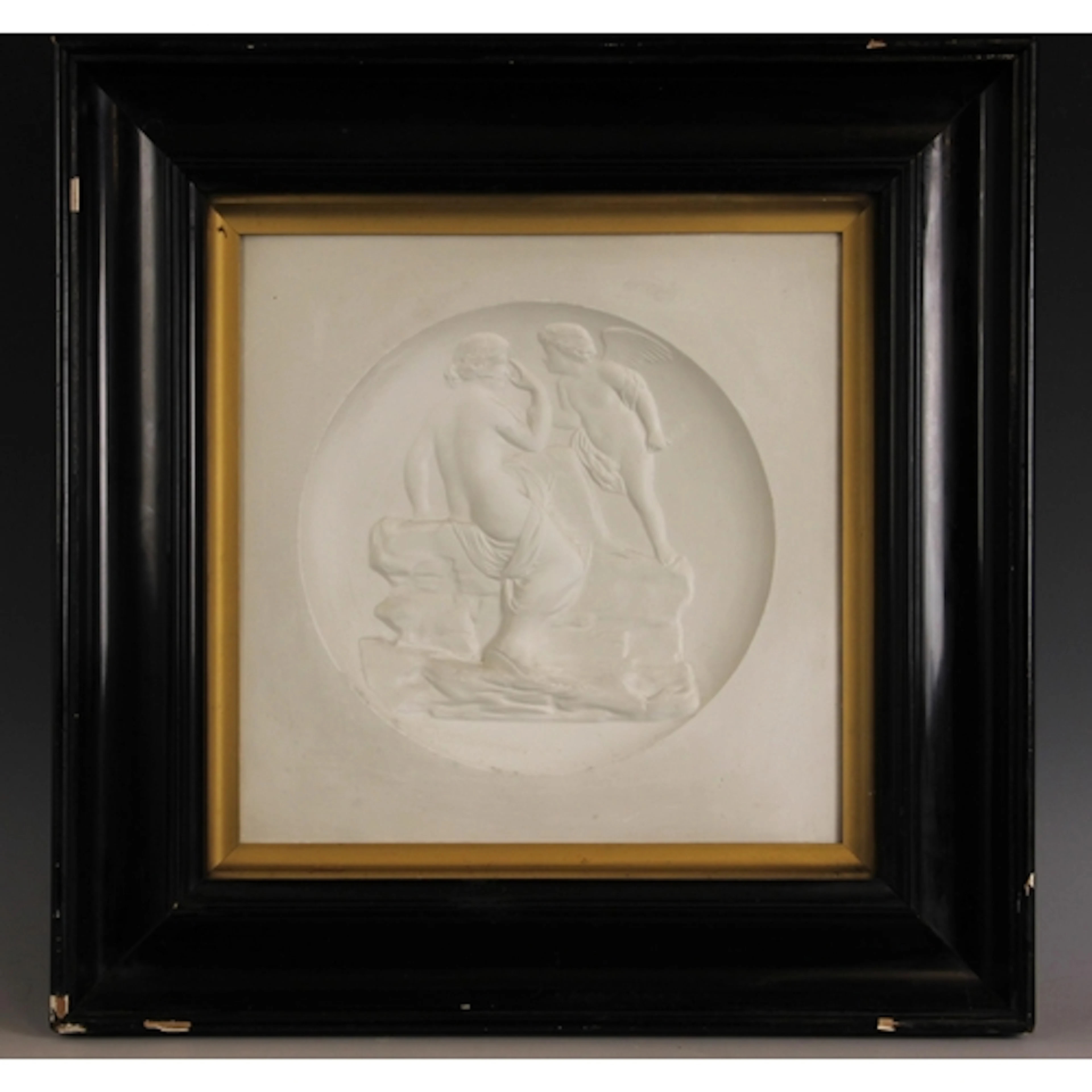A relief moulded plaster tondo panel depicting Venus and Cup...