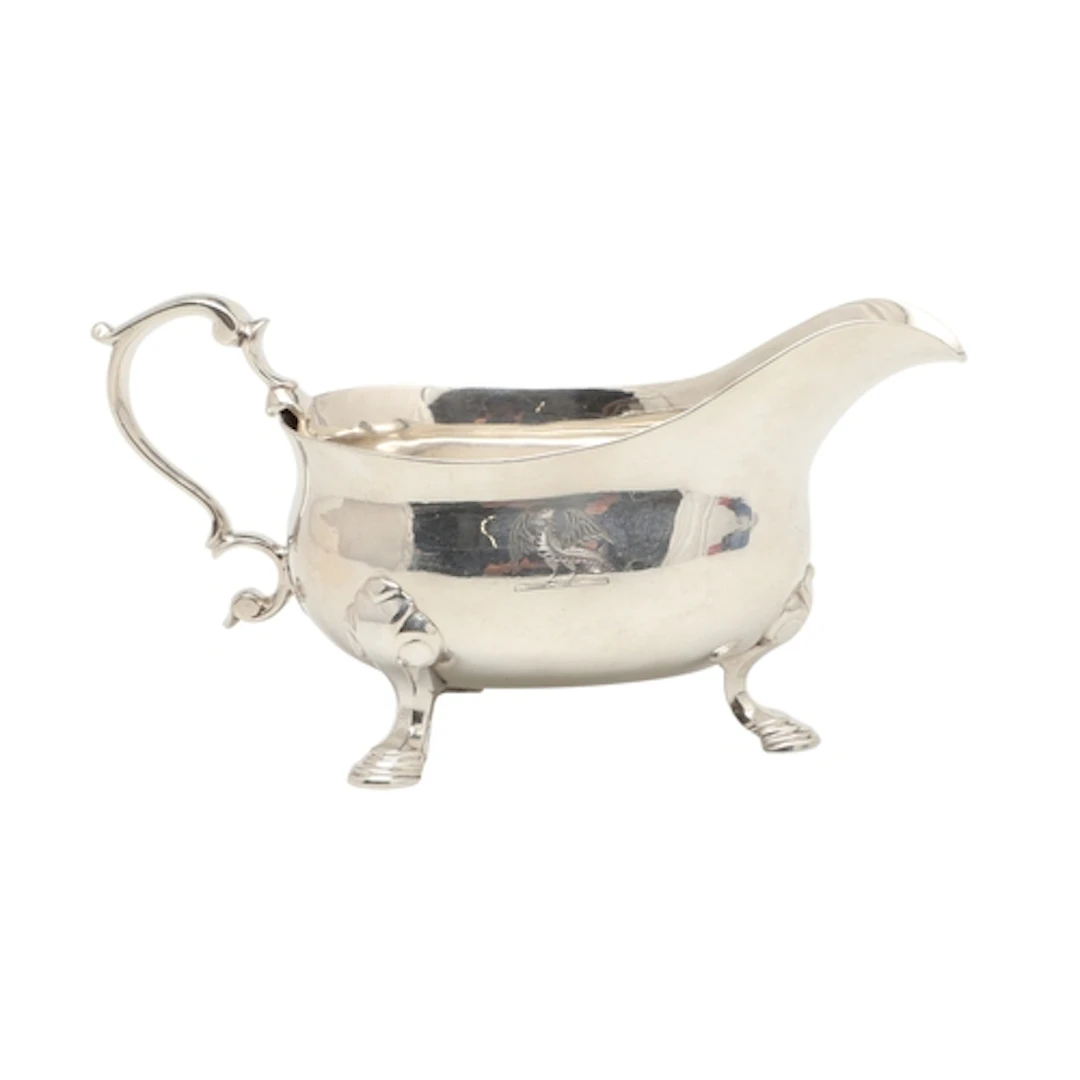 A GEORGE II SMALL SILVER SAUCE BOAT. Engraved with a crest, ...