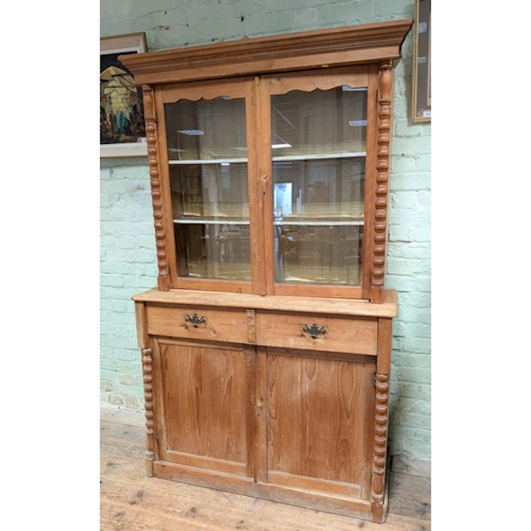 A late Victorian pine two door glazed bookcase on a cupboard...