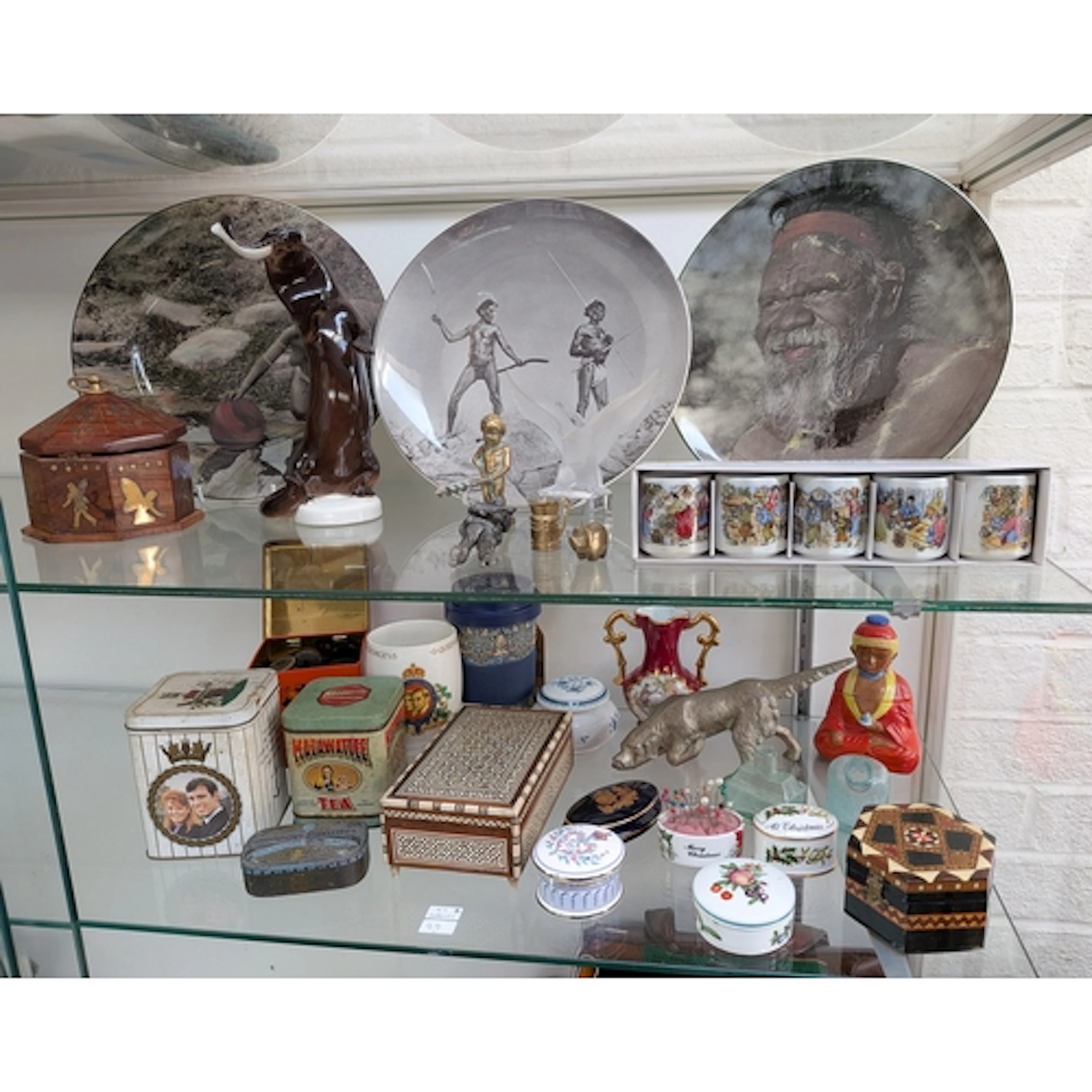 Collectables on two shelves - to include three African scene...