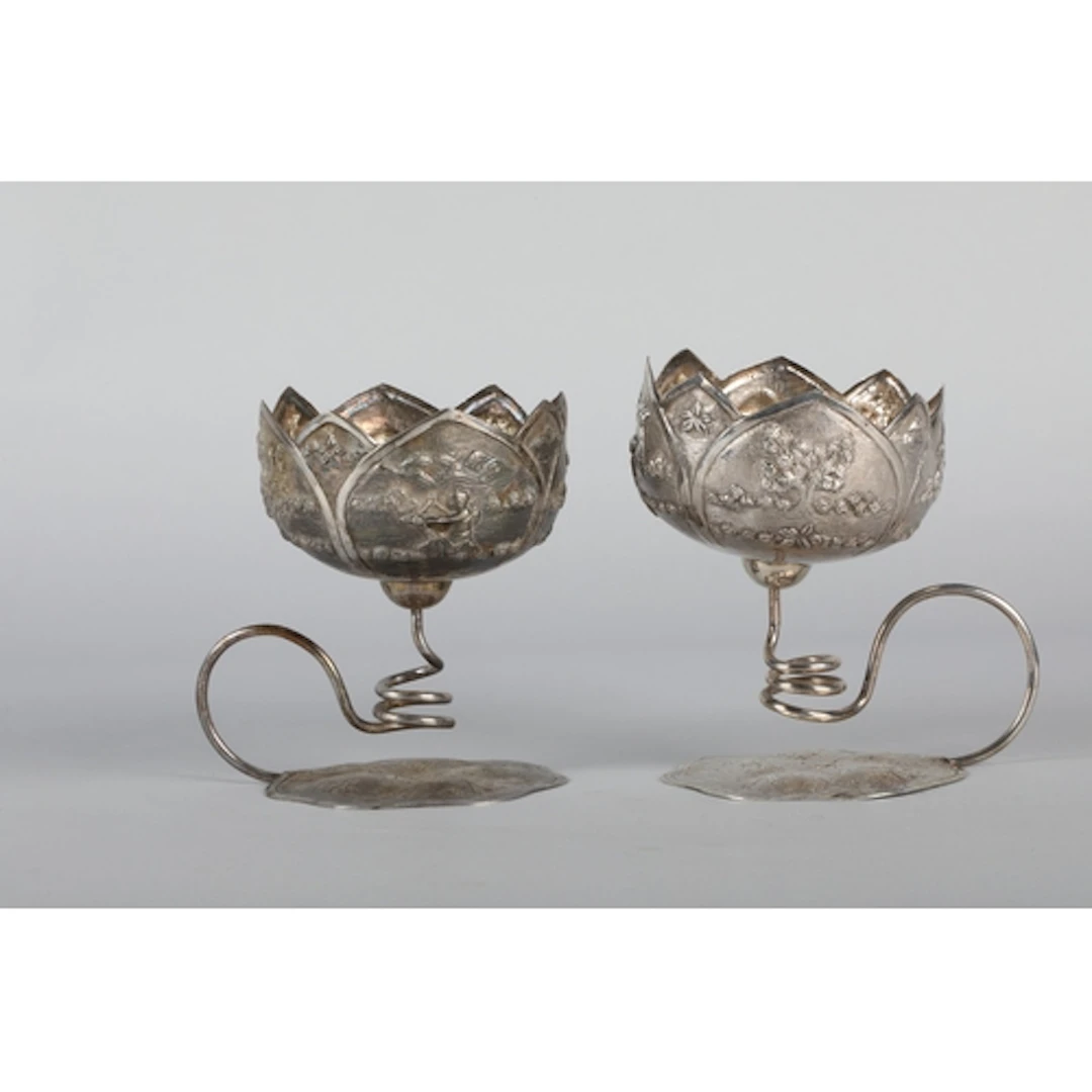 Eastern white metal high relief cup on a lily pad base.